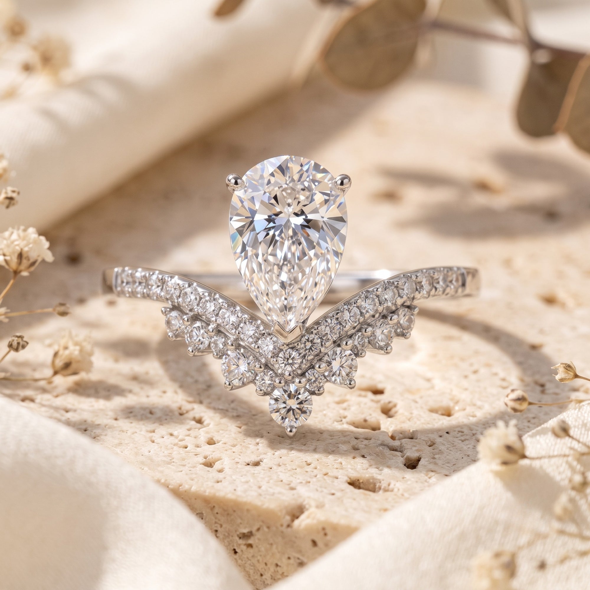 Sterling silver wishbone ring with pear-cut simulated diamond on stone with dried flowers.