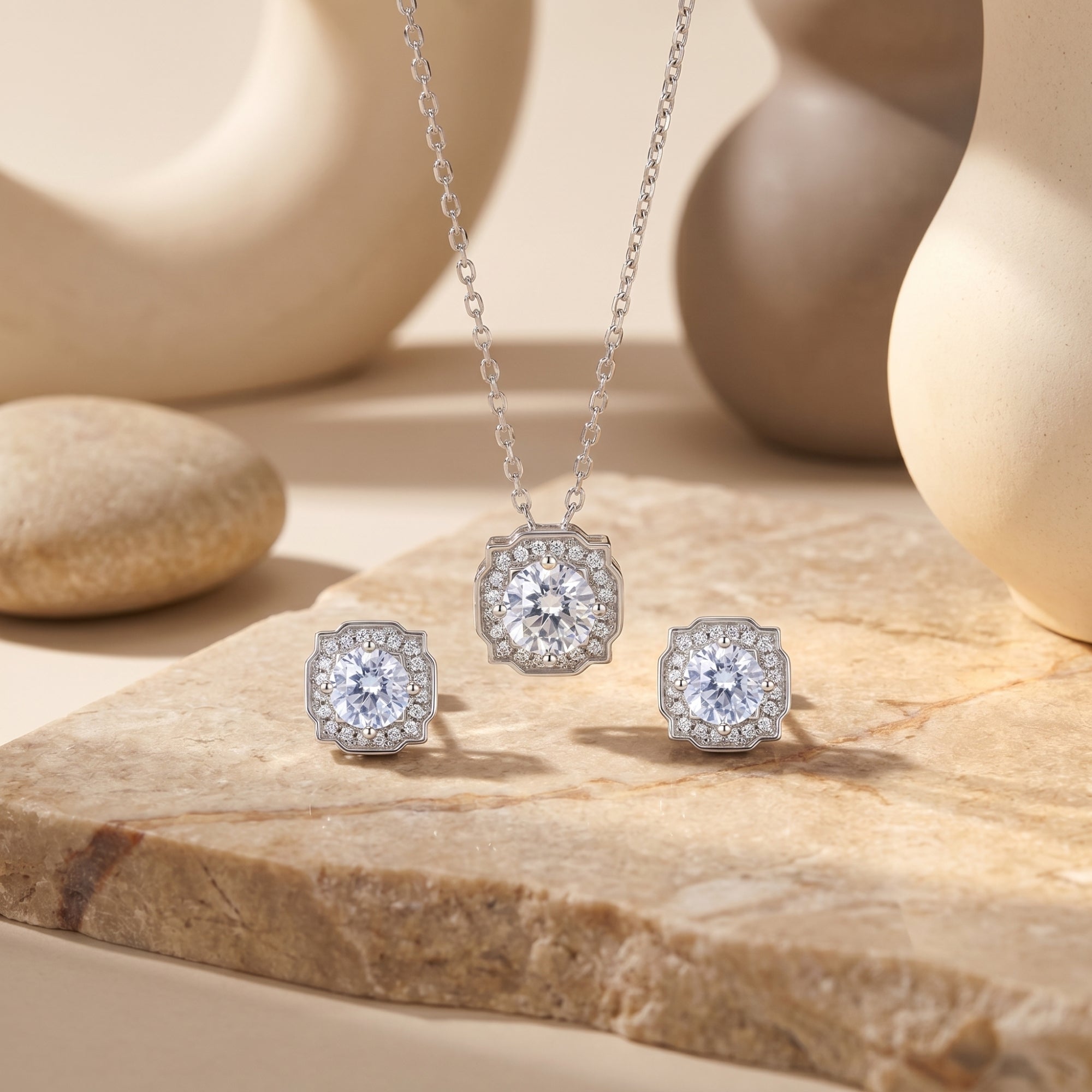 Aurestella round-cut moissanite halo necklace and stud earrings set in silver on a stone lifestyle background.