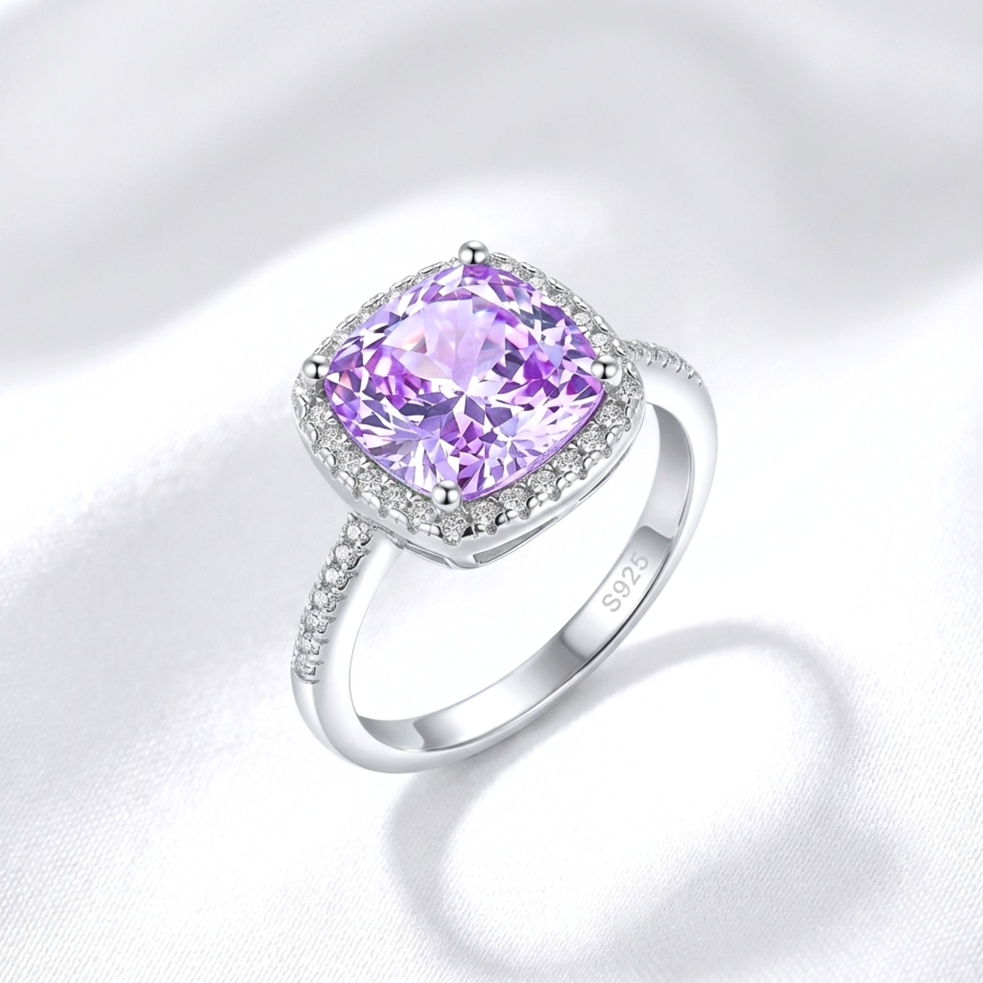 Cushion cut purple simulated amethyst halo ring in S925 sterling silver on a white silk background.