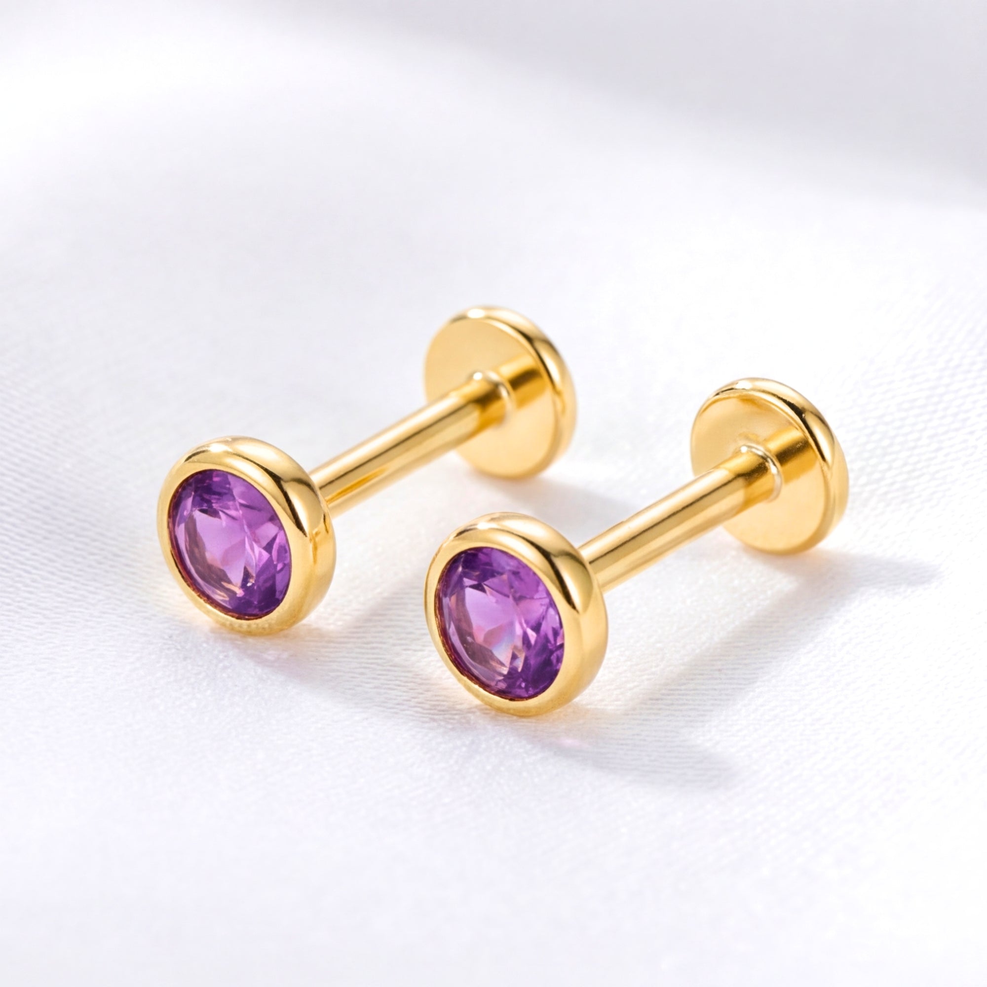 Pair of 18K gold vermeil simulated amethyst earrings with flat-back posts on a white fabric background.