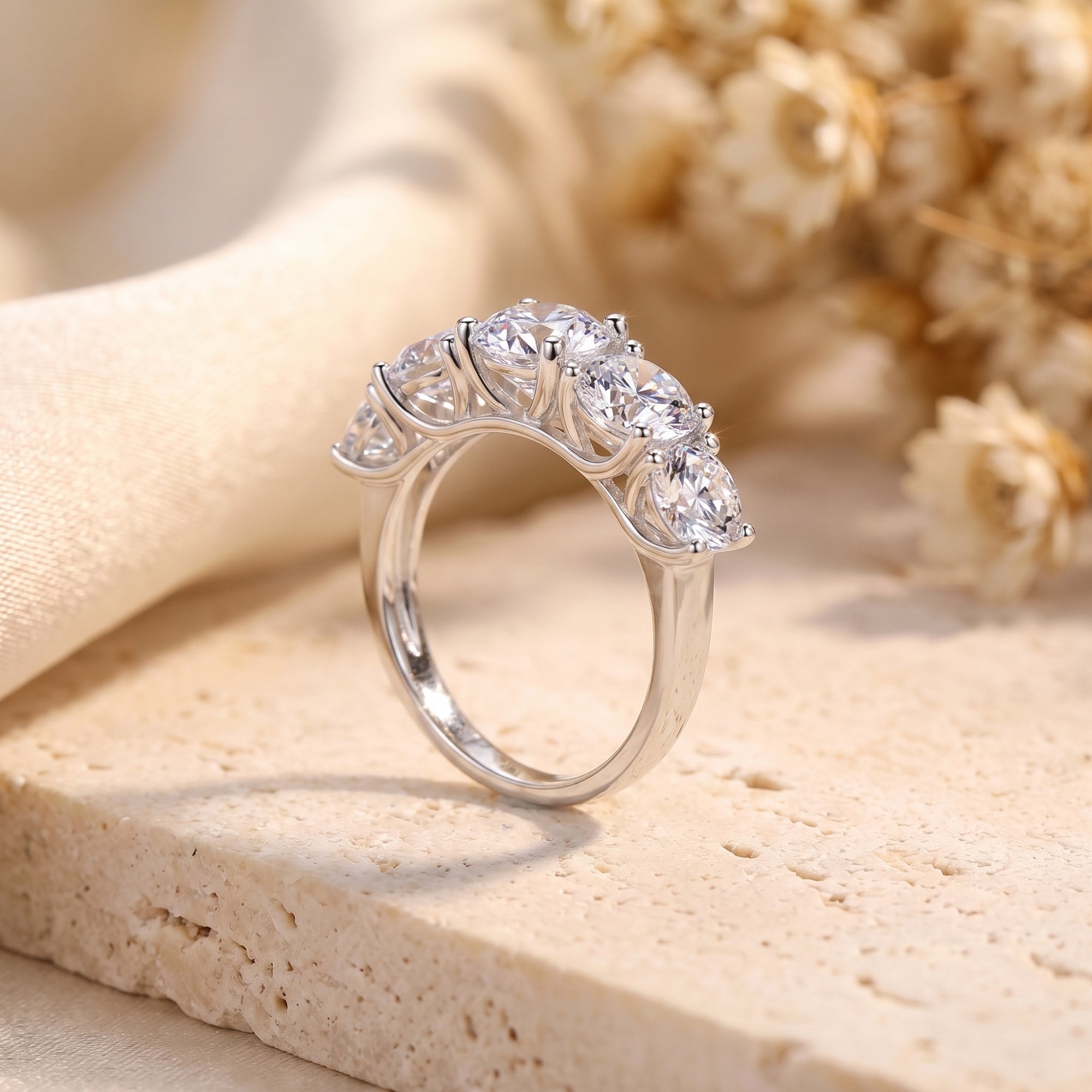 Side view of the Claralise sterling silver ring showing five graduated round-cut simulated diamonds in basket settings.