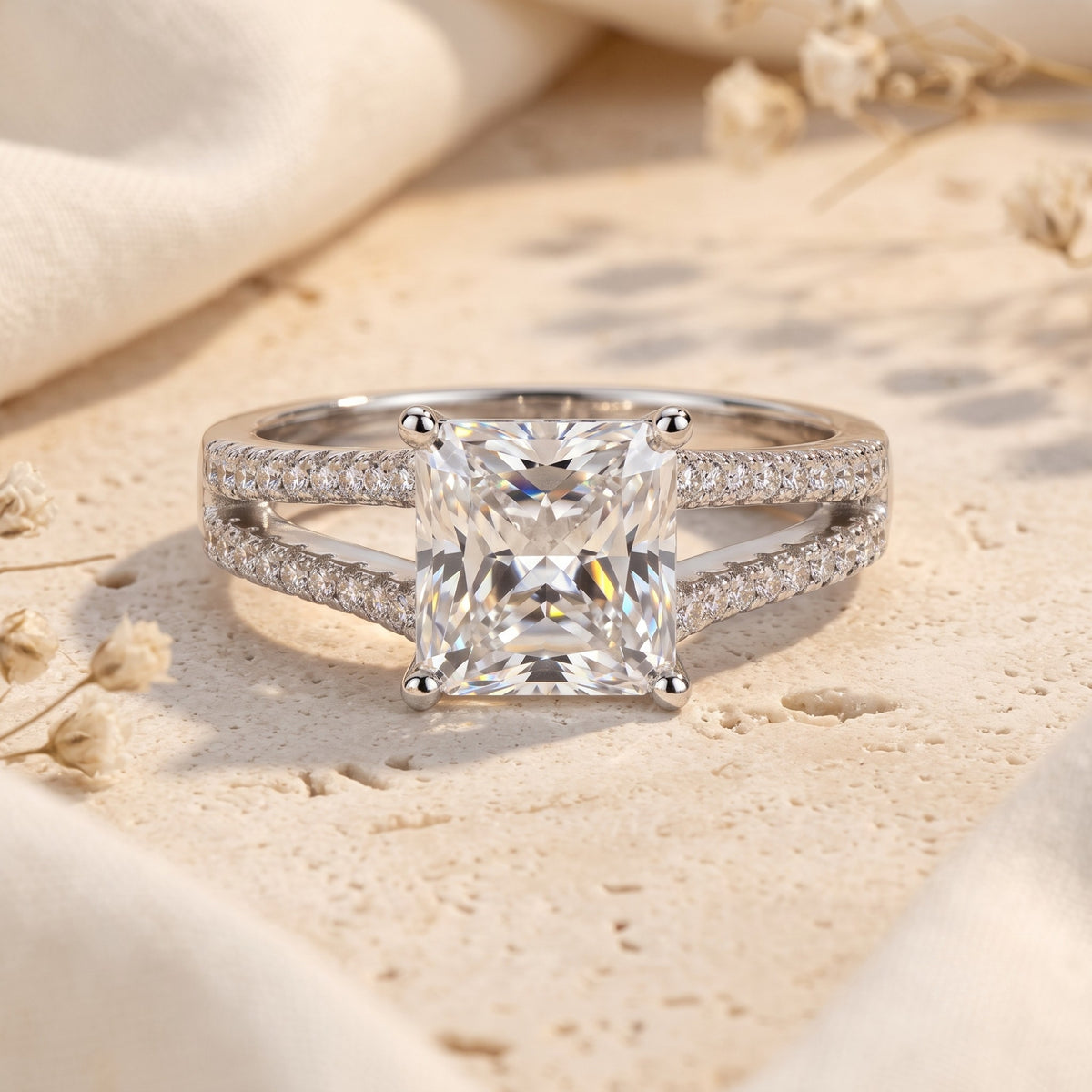 Front view of the silver split-shank solitaire ring with a princess-cut center stone and pave band.