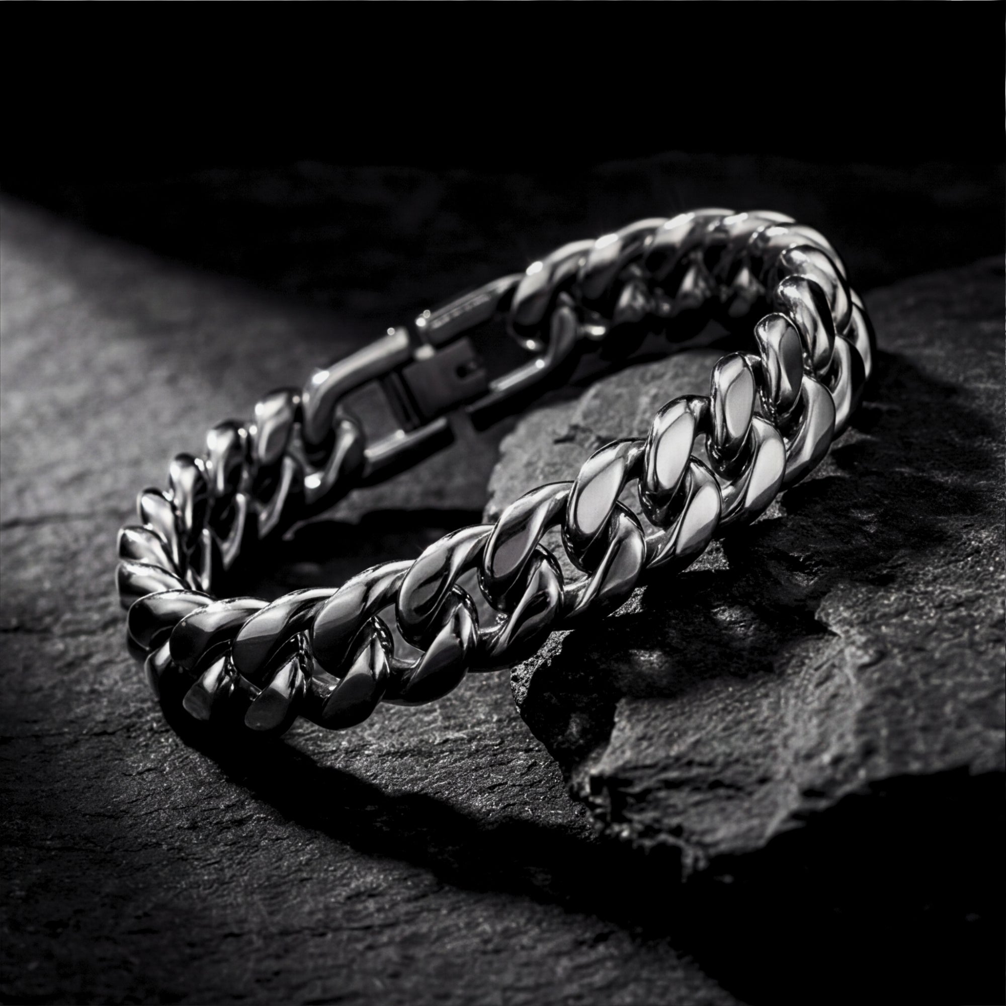 Silver 12mm stainless steel Cuban link bracelet resting on a dark textured rock surface.