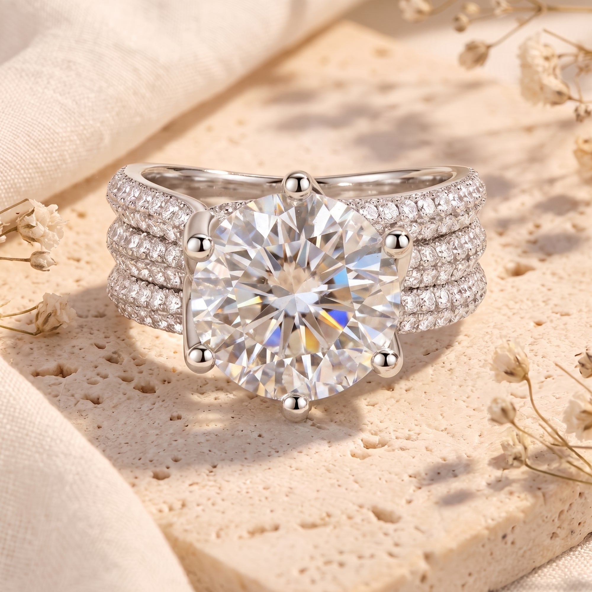 Round simulated diamond sterling silver ring with triple-row pavé band on stone background.