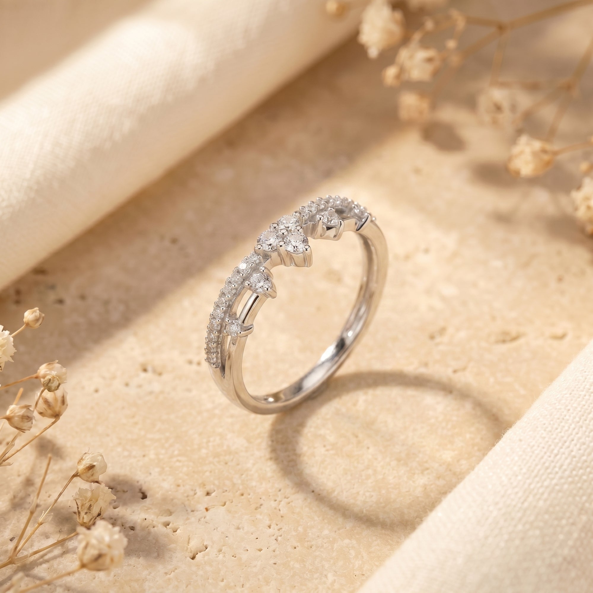 Silver crown-inspired tiara ring with brilliant simulated diamonds on a textured lifestyle background.