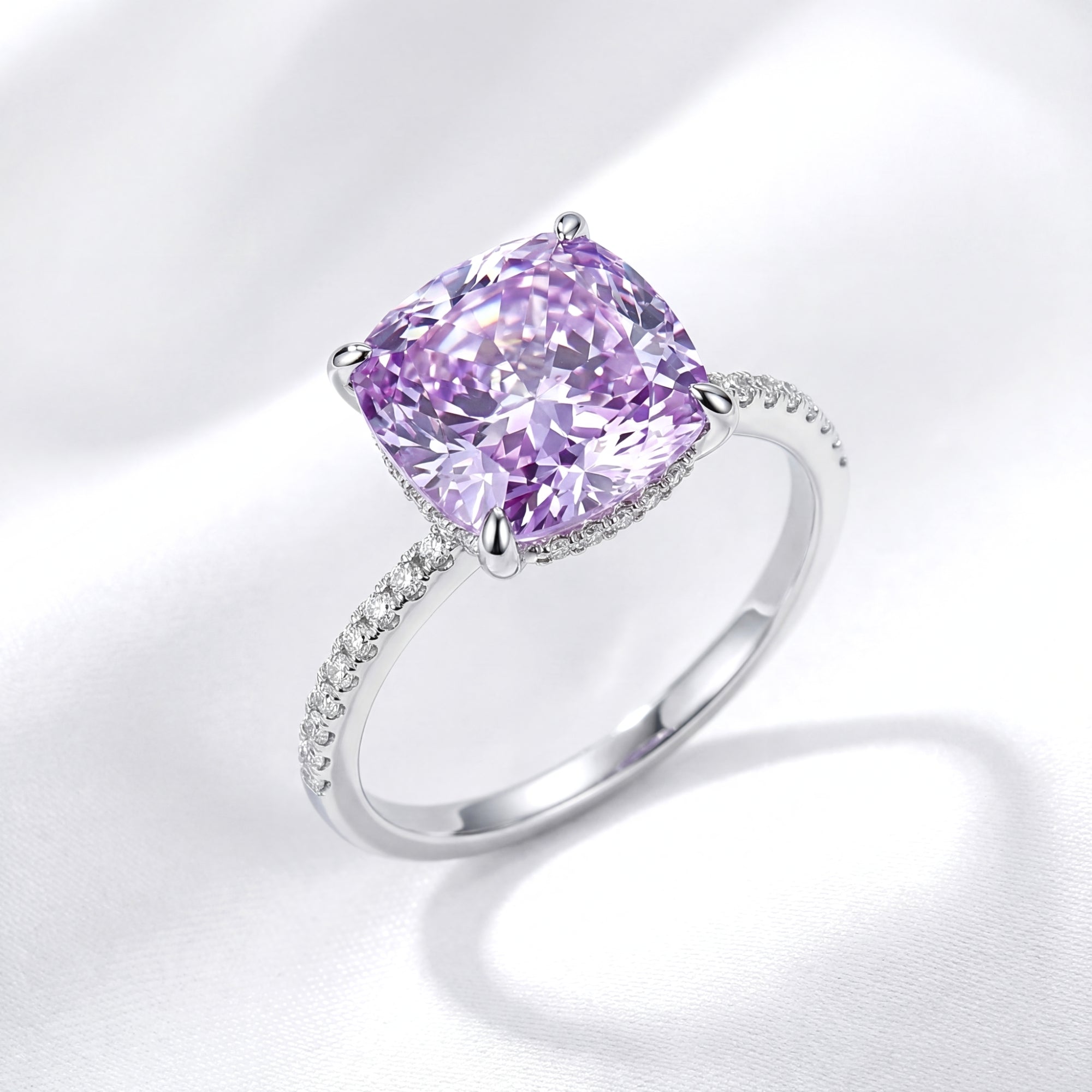 Cushion cut simulated amethyst halo ring in S925 sterling silver on a white silk background.