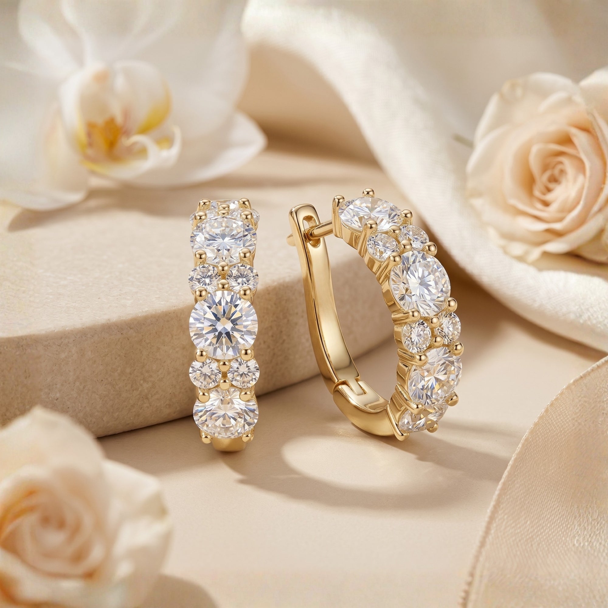 Gold moissanite hoop earrings with round stones on a floral background.