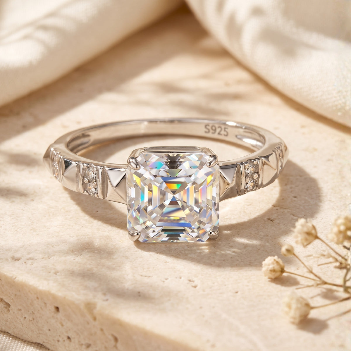 Front view of the silver ring featuring a square radiant-cut stone on a pyramid-patterned, pave-accented band.