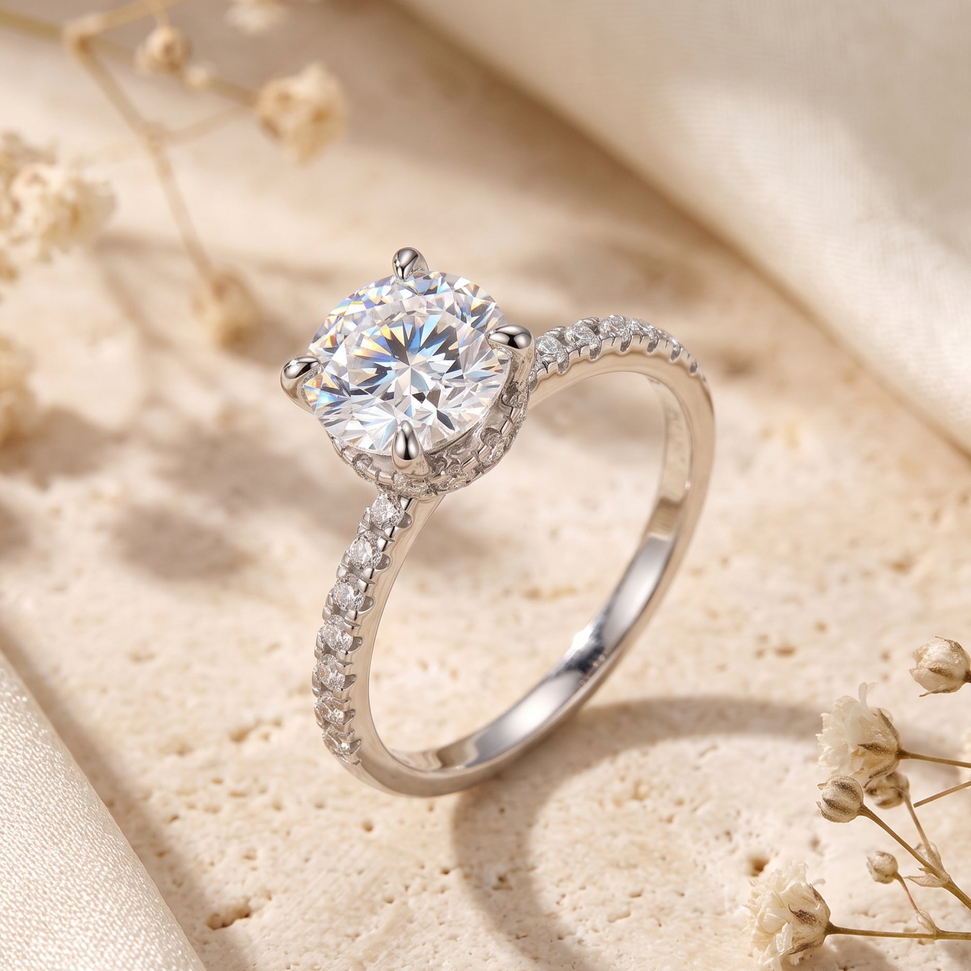 Side view of the Elorina sterling silver ring with a round simulated diamond and hidden halo on a stone surface.