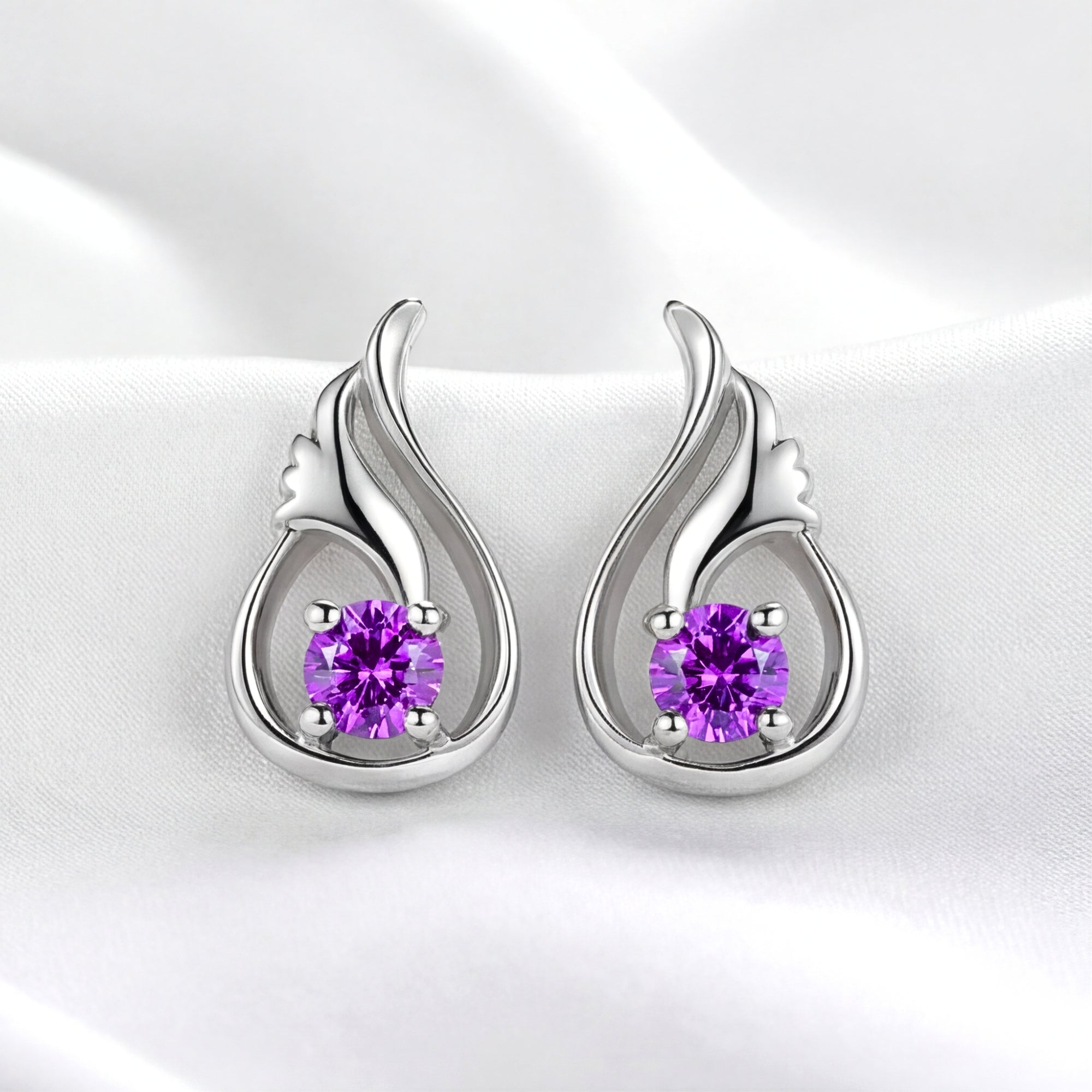 S925 sterling silver Lysithea drop earrings with round-cut simulated amethyst in a tulip bud setting on white fabric.