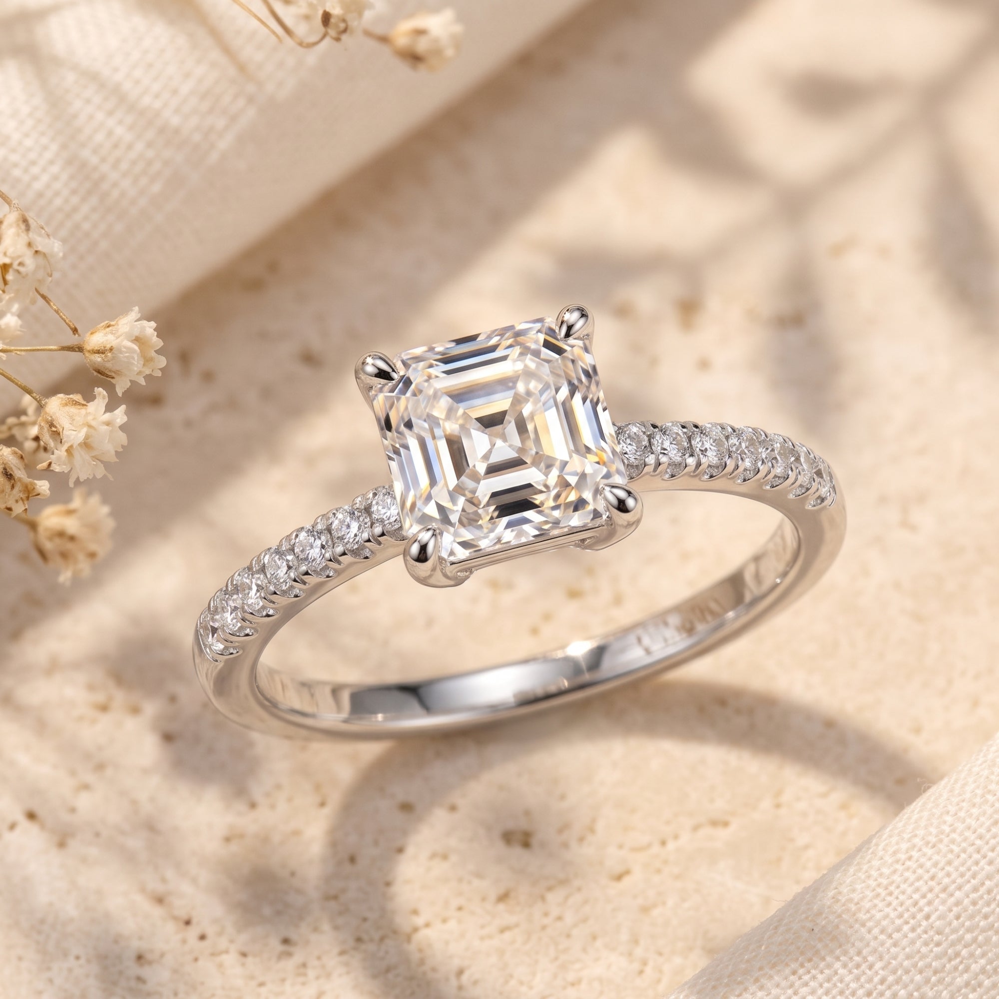 Princess cut CZ silver promise ring on stone with dried flowers.