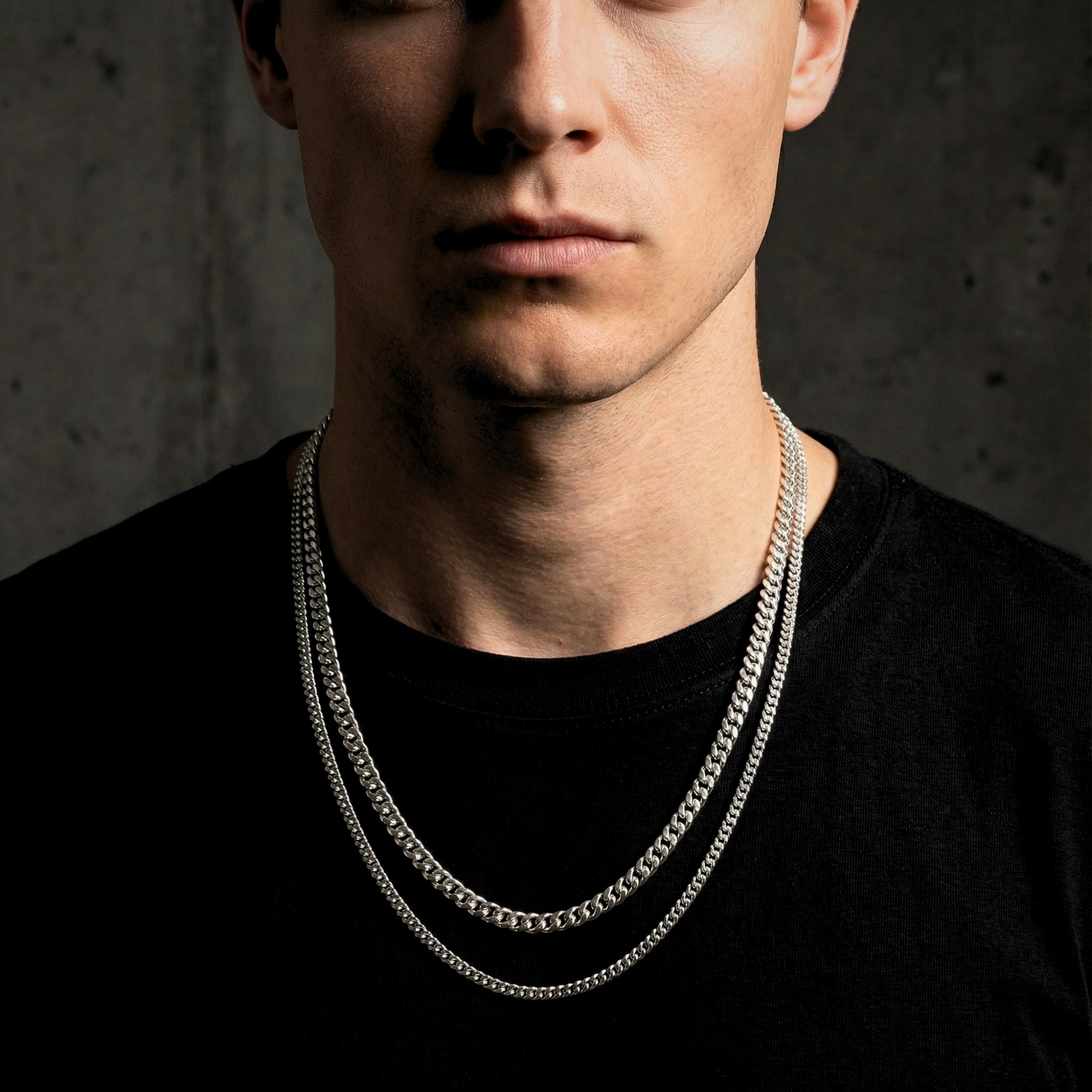 Model wearing the Cuban Duo stacked necklace set in polished silver stainless steel over a black t-shirt.