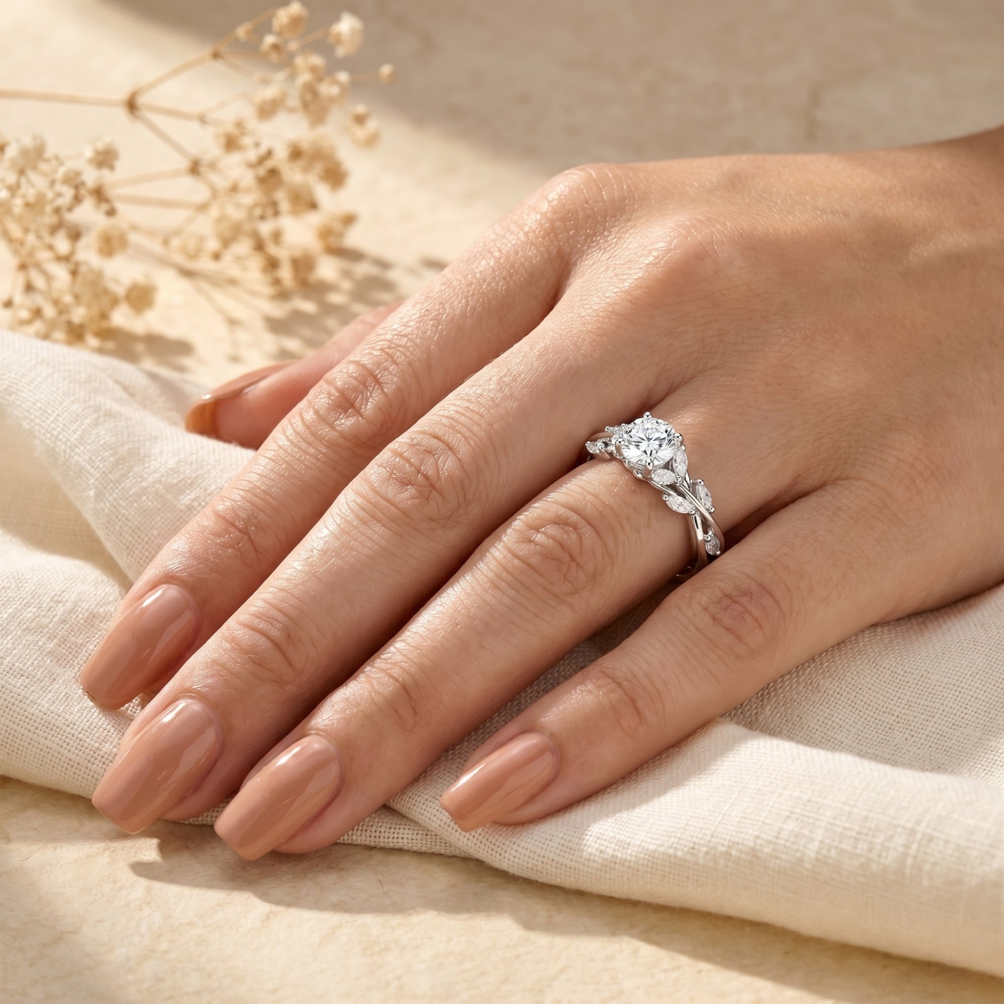 Calyxta moissanite ring with round center stone and marquise accents worn on a woman's hand.