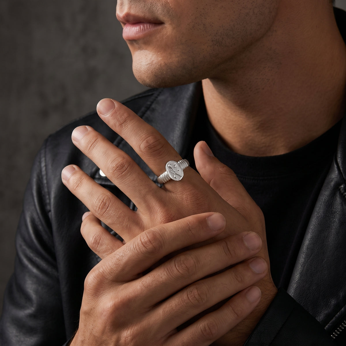 Model wearing the silver tulip signet ring on an index finger over a black leather jacket.