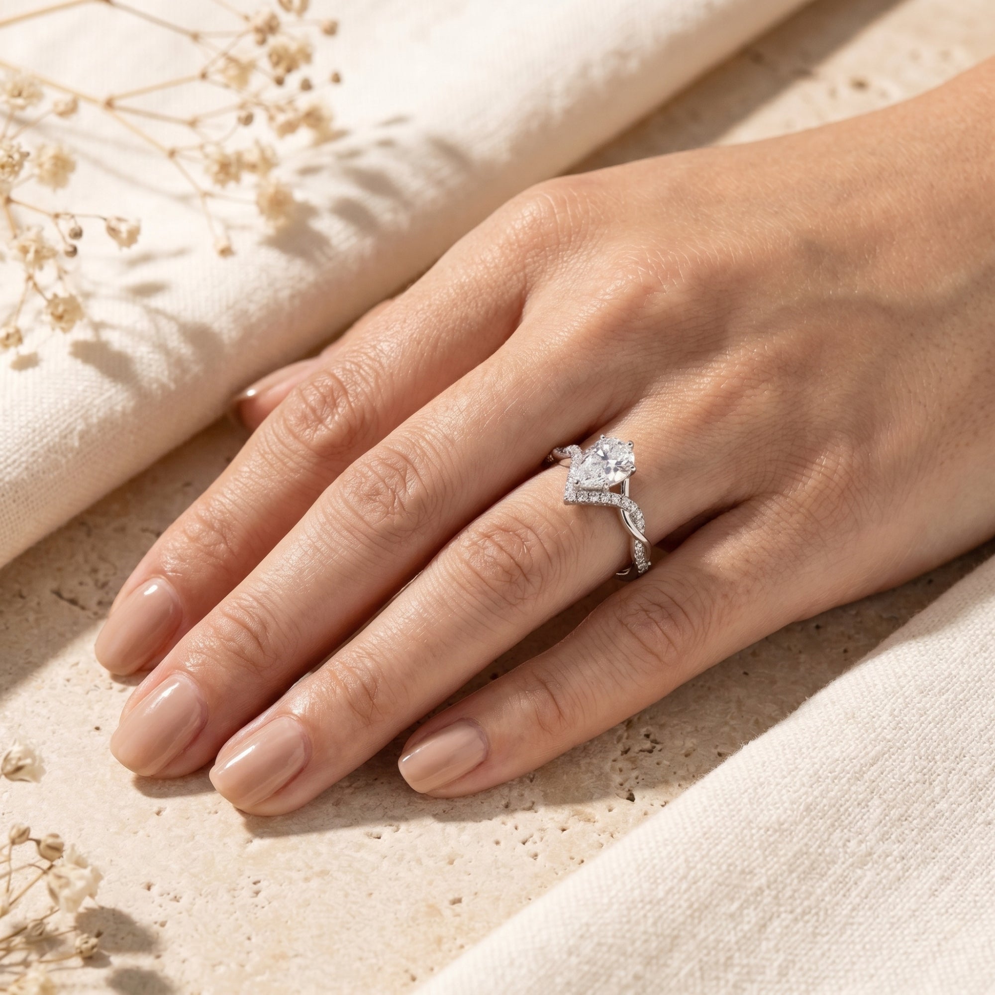 Woman wearing the silver Araminta pear-cut moissanite promise ring on her ring finger.