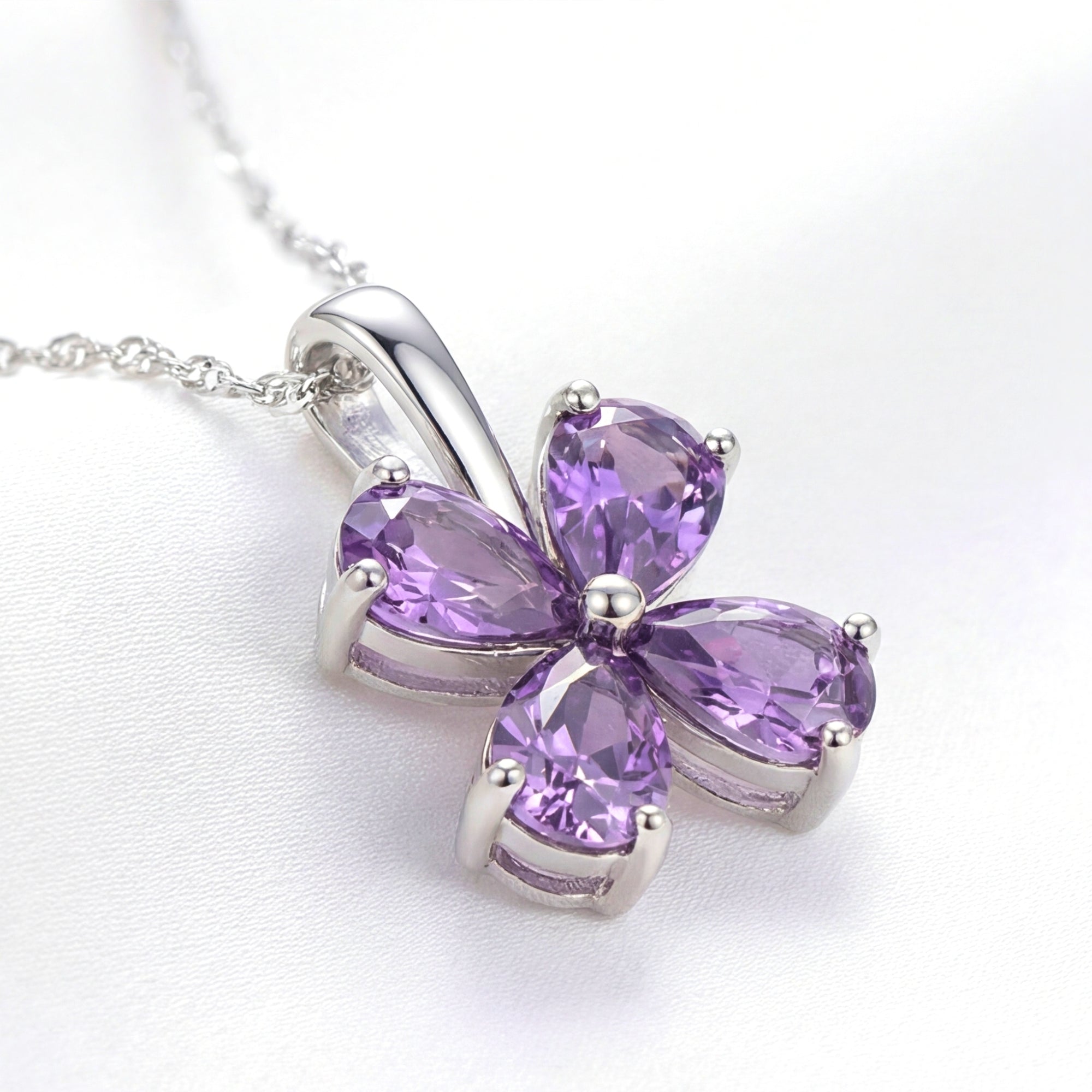 Close-up of the Amity clover pendant showing the S925 sterling silver setting and faceted purple simulated amethysts.