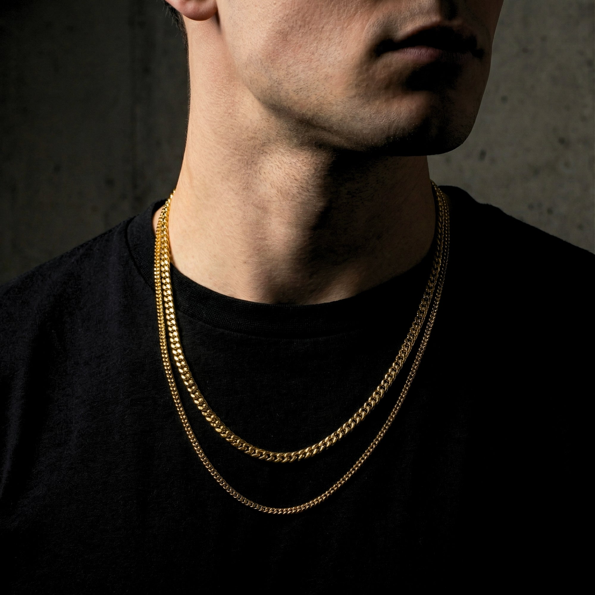 Male model wearing the layered Golden Duo Cuban Set of two gold stainless steel chains.