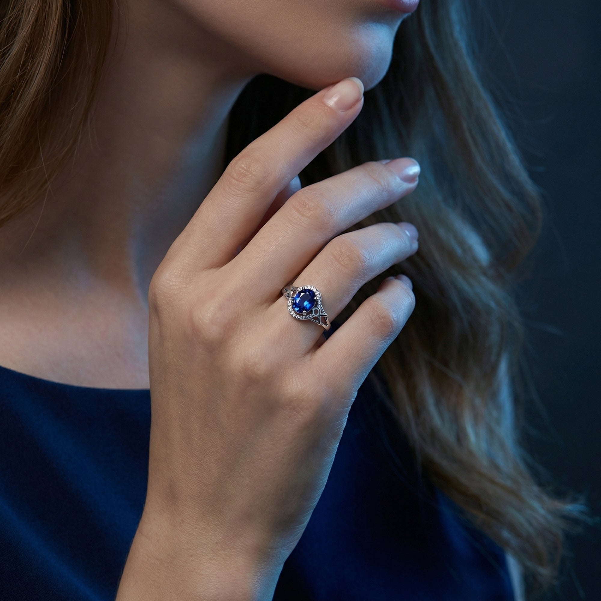 Woman wearing the Alysandra oval tanzanite and diamond ring in 18K white gold on her finger.
