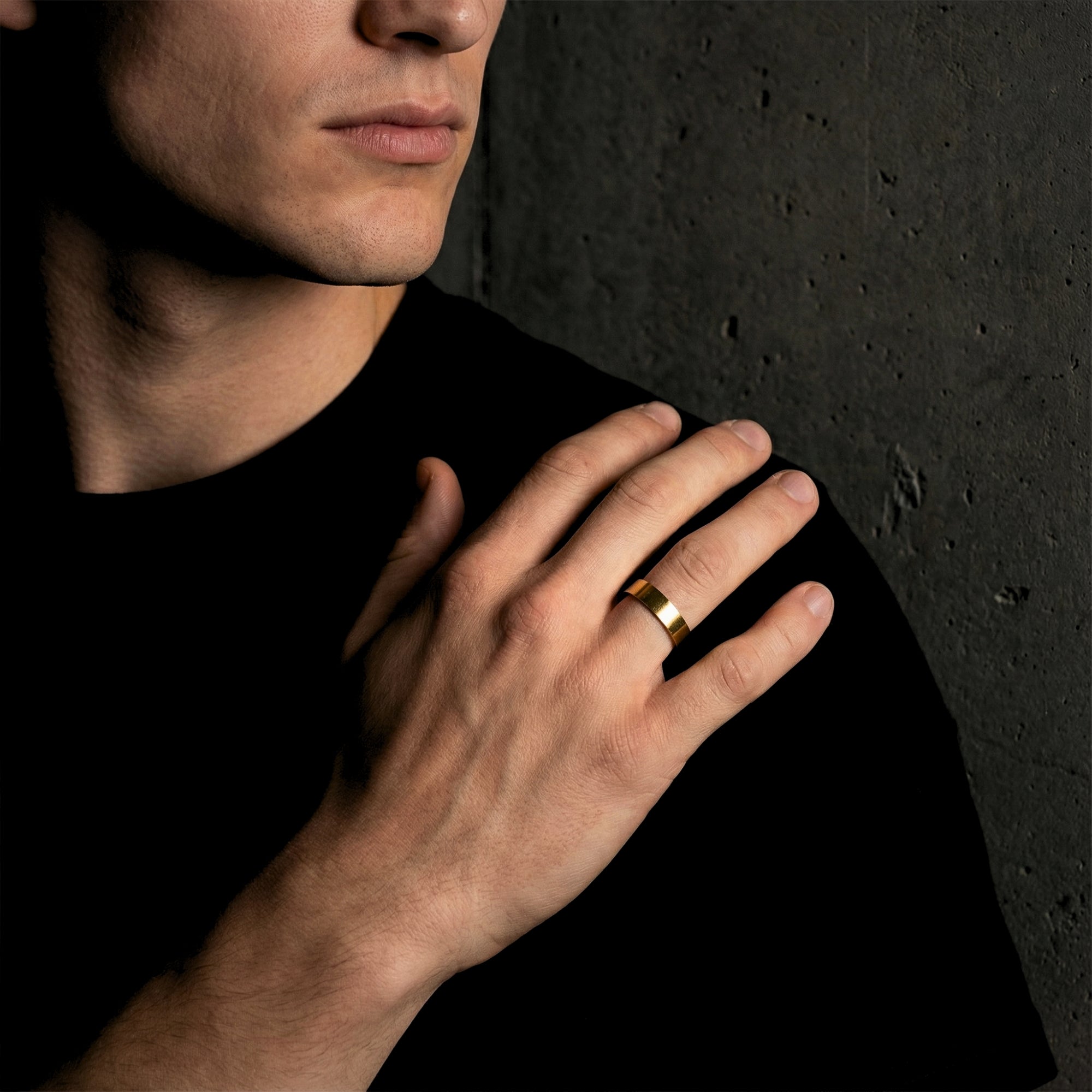 Men's gold stainless steel gap ring worn by a model with his hand resting on his shoulder.
