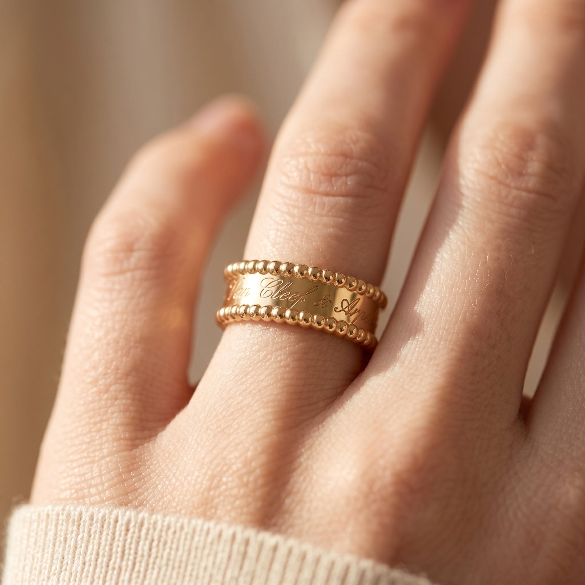 Close-up of The Vowbound Ring in 18K gold vermeil worn on a finger, showing the detailed script engraving.