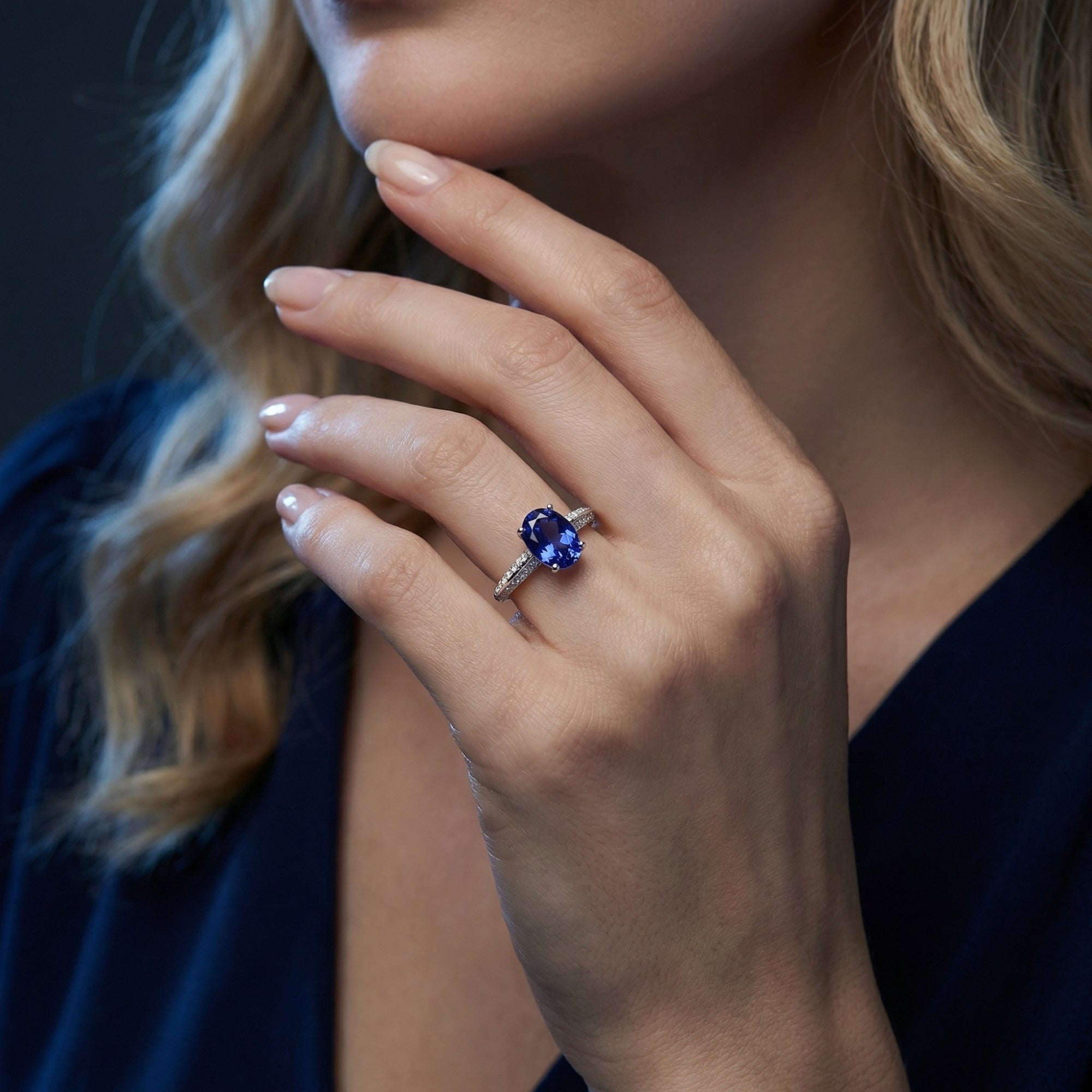 Woman wearing the Novalise oval tanzanite ring in sterling silver on her hand, showcasing the deep blue gemstone.