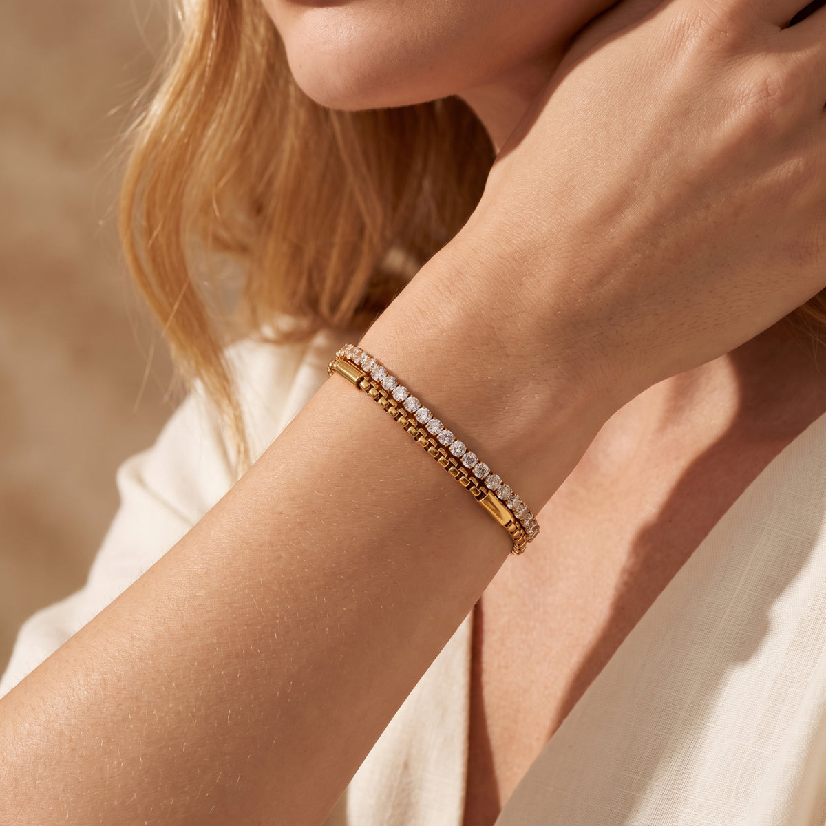 Model wearing the gold-tone double-layer box chain and cubic zirconia bracelet on her wrist.