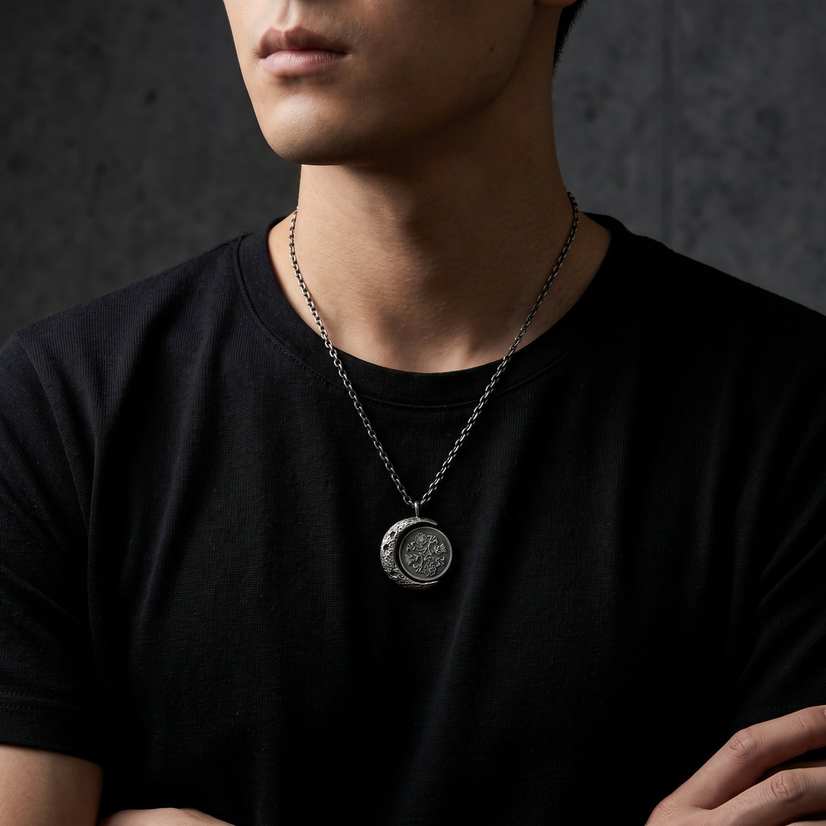 Model wearing the silver lunar coin pendant necklace over a black T-shirt, with the pendant at mid-chest.