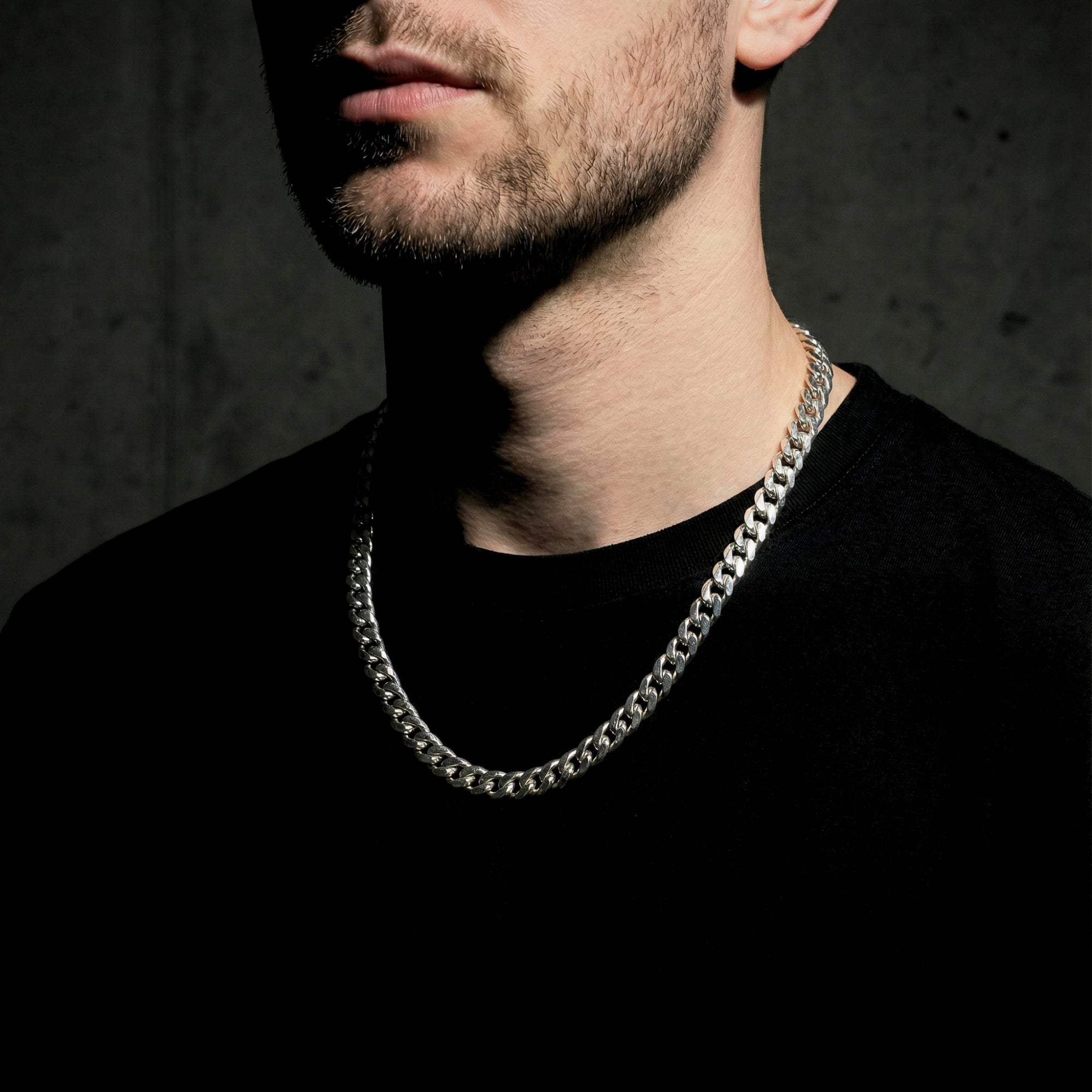 Man wearing the silver 8mm stainless steel Cuban link chain over a black t-shirt.