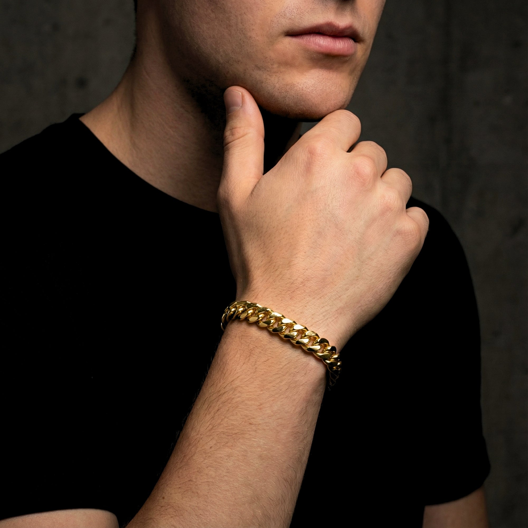 Close-up of a man wearing a 10mm gold stainless steel Cuban link bracelet on his wrist.