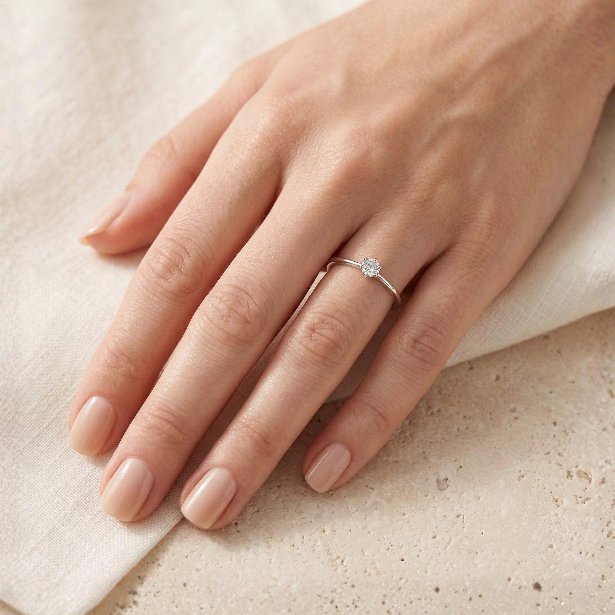 Sterling silver 0.5CT round moissanite ring on a model's hand.