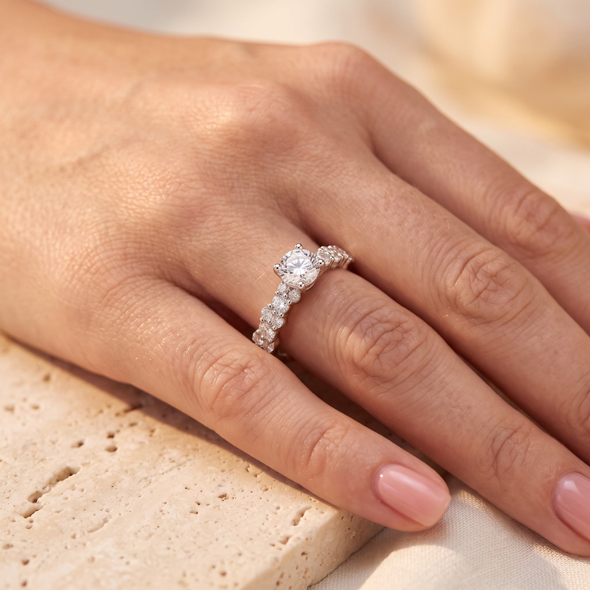 Round simulated diamond Cassandra ring worn on a model's hand.