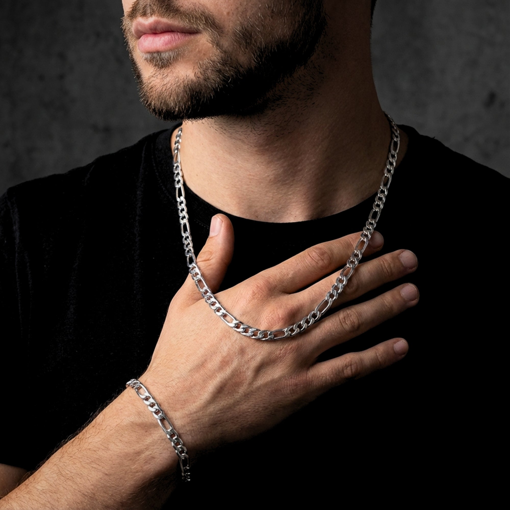Man wearing a silver 8mm stainless steel Figaro chain and matching bracelet over a black t-shirt.