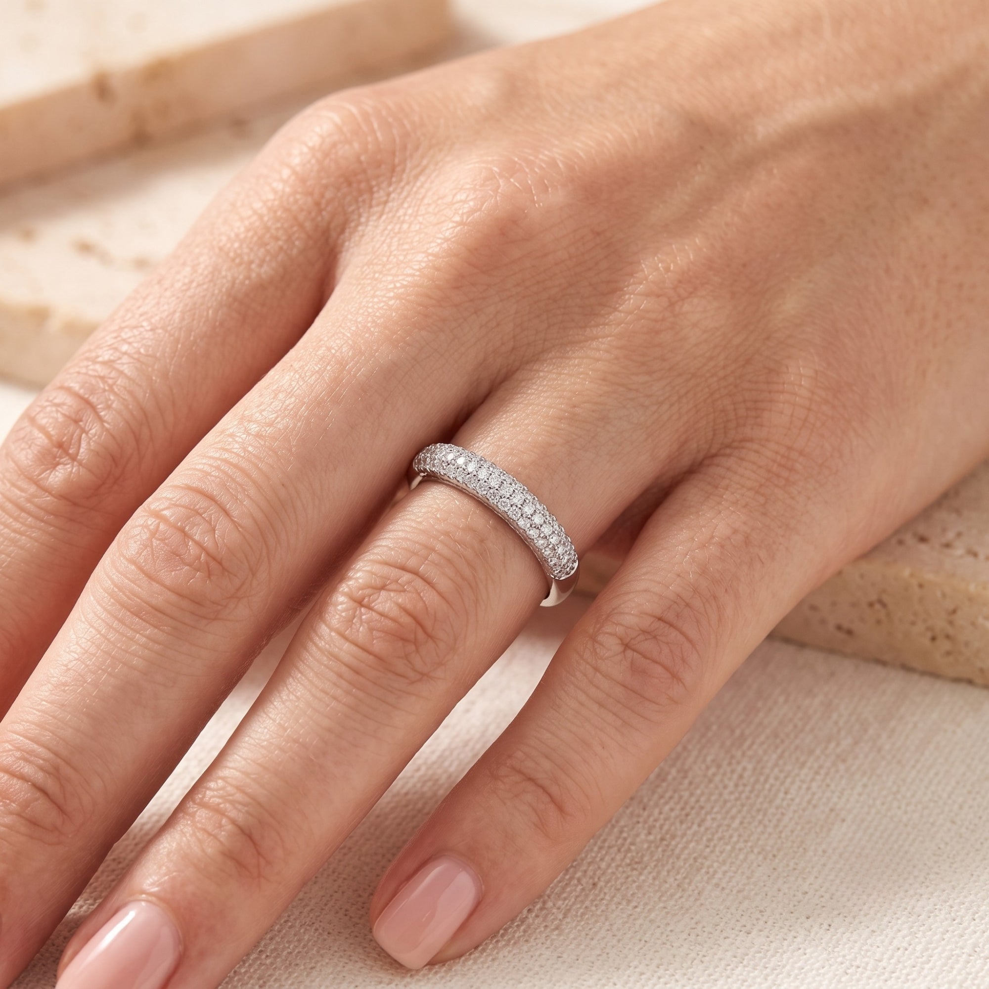 Florentina sterling silver band featuring three rows of simulated diamonds worn on a woman's finger.