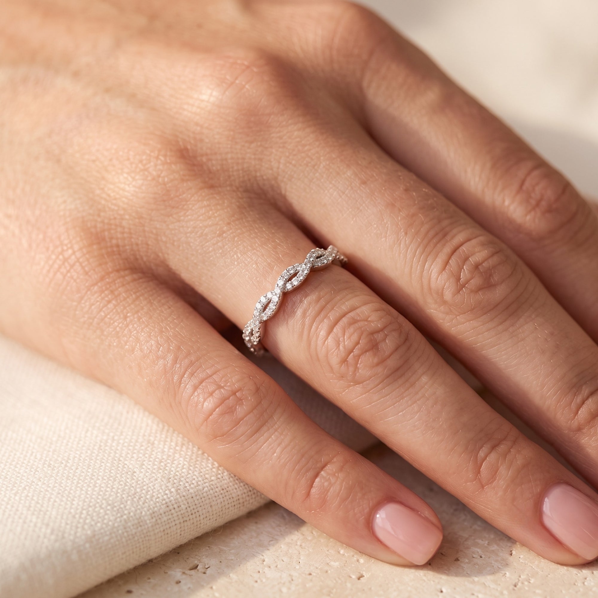 Helena twisted silver ring with simulated diamonds worn on a woman's finger.