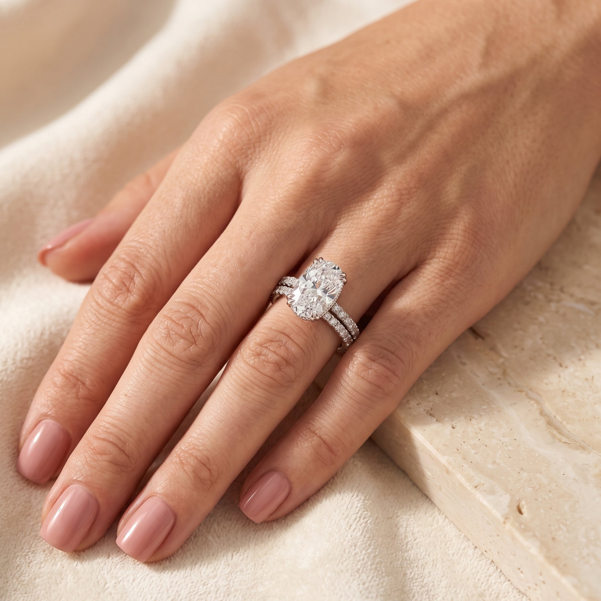 Oval-cut simulated diamond ring set in sterling silver worn on a woman's hand.