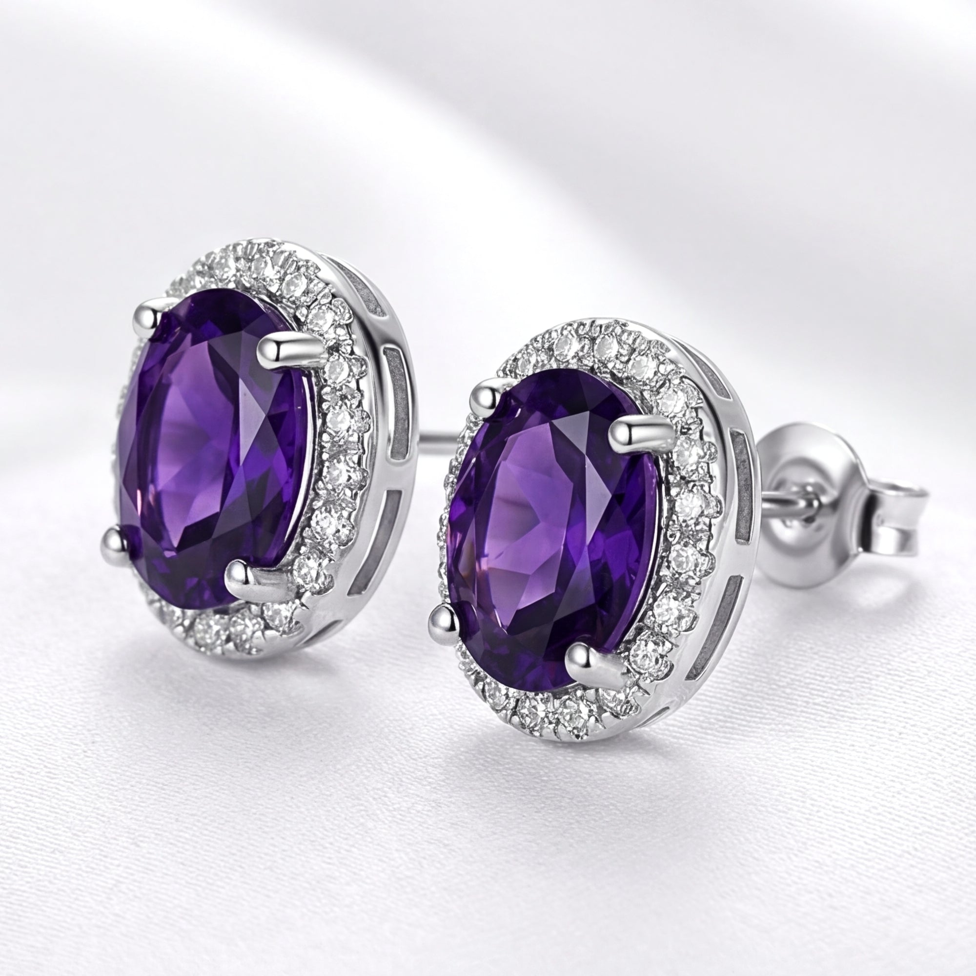 Side view of oval purple amethyst halo studs in S925 sterling silver showing the basket setting and posts.