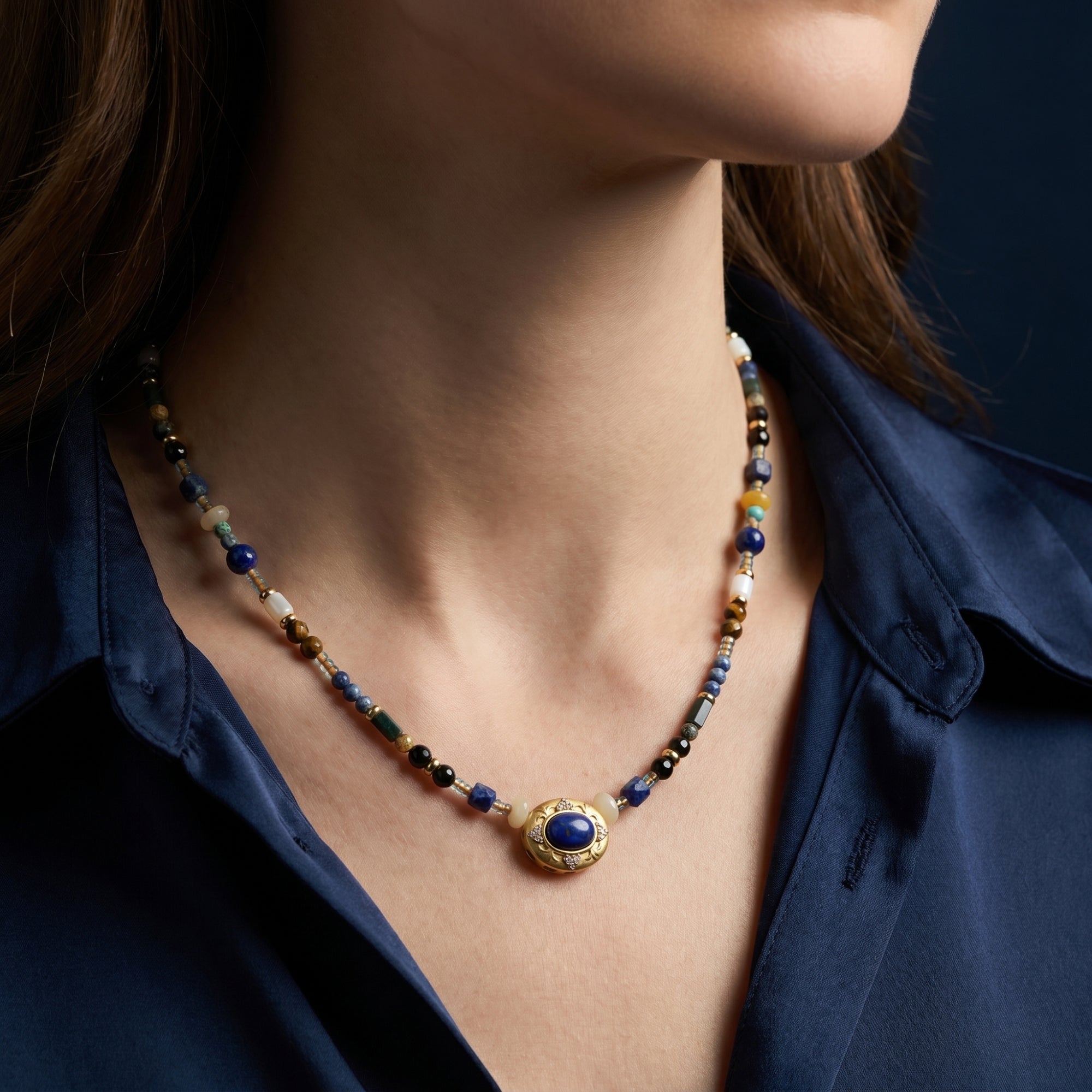 Model wearing the yellow gold plated Celestial Path necklace with blue lapis lazuli and tiger's eye beads.