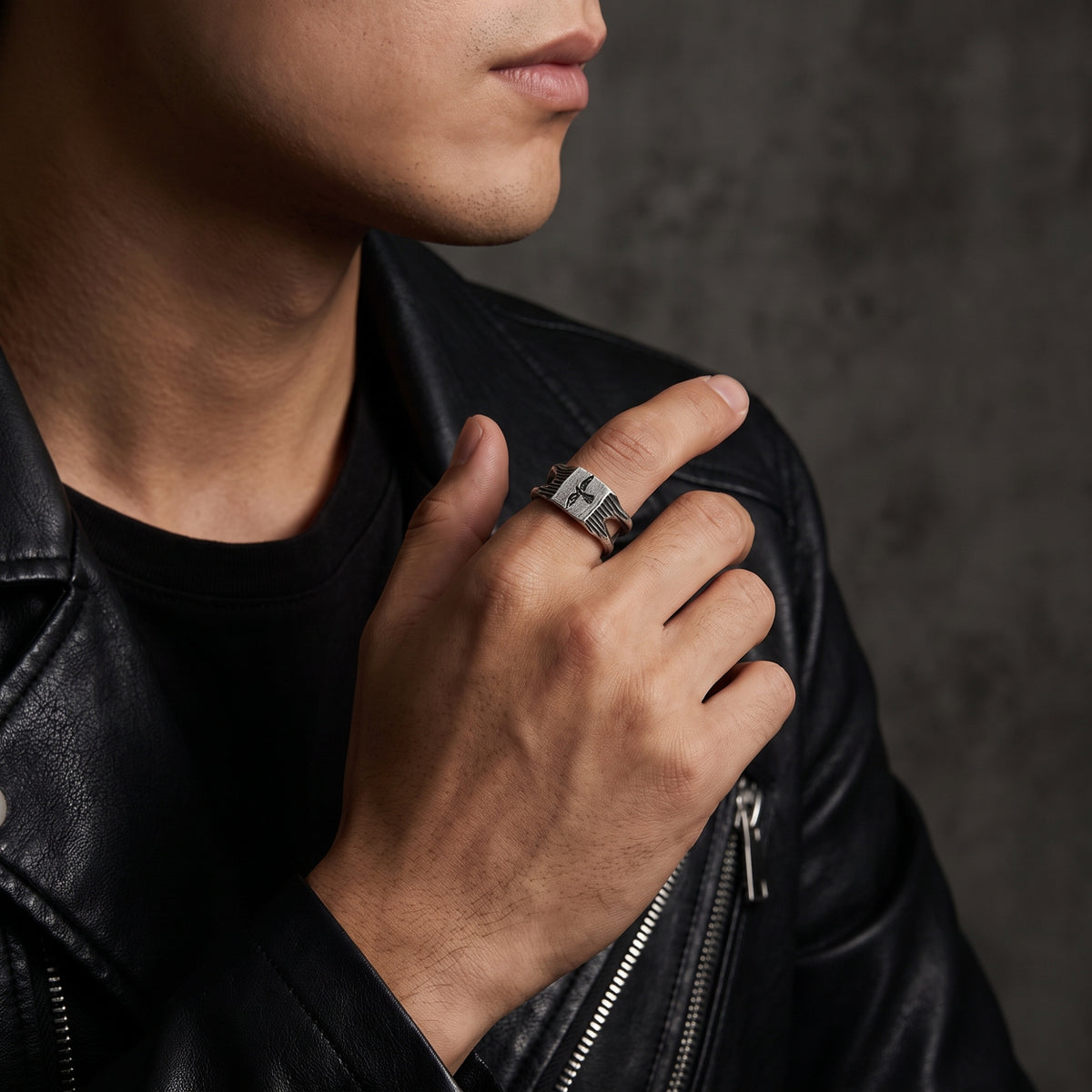 Model wearing the silver falcon signet ring on his index finger with a black leather jacket.