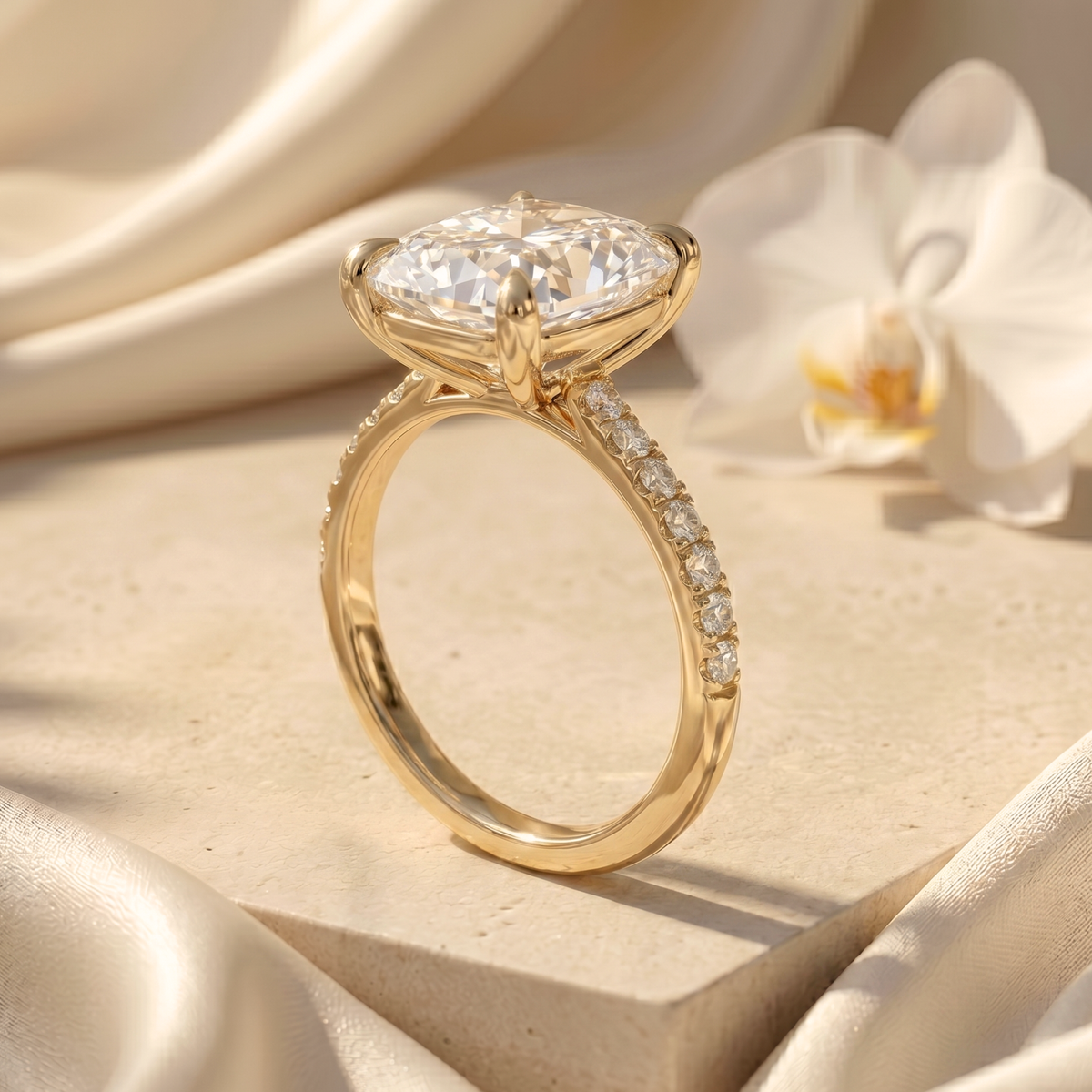 Profile view of a gold cushion-cut moissanite ring displaying the intricate prong setting and pave band details.