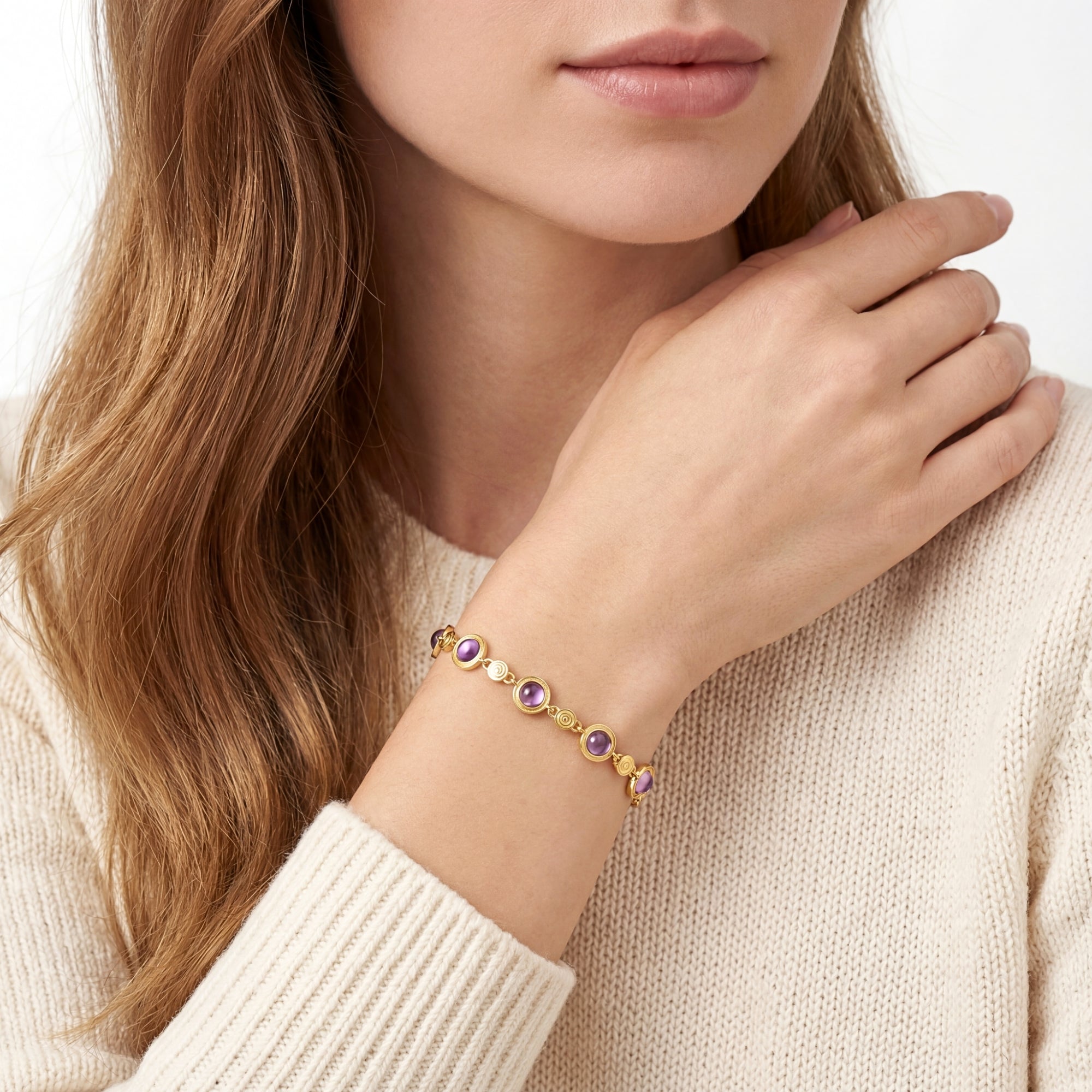 Model wearing the 18K gold vermeil Evangeline station bracelet with purple round cut simulated amethyst stones.