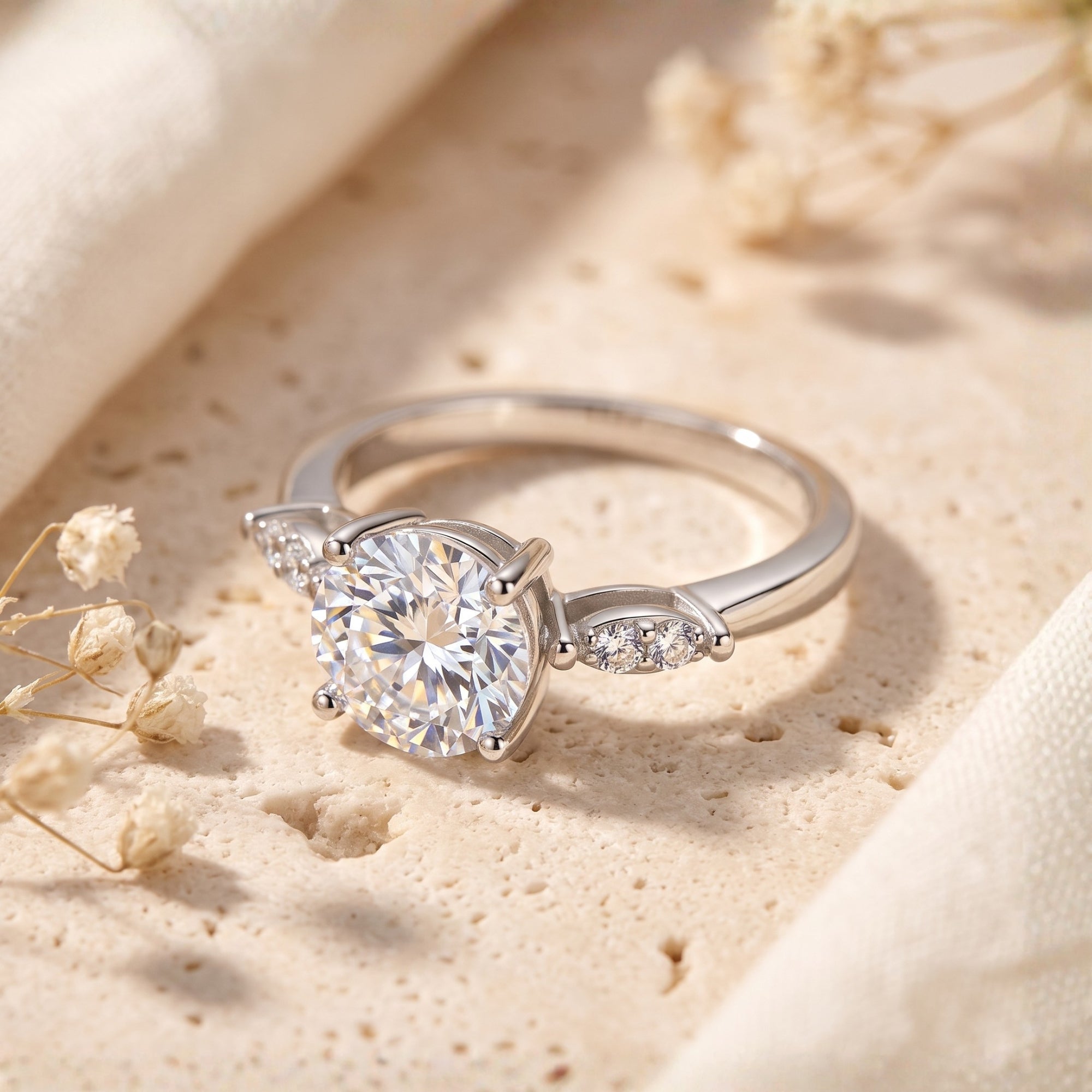 Close-up of the Claudine round cut cubic zirconia ring showing the four-prong setting and side stone accents.