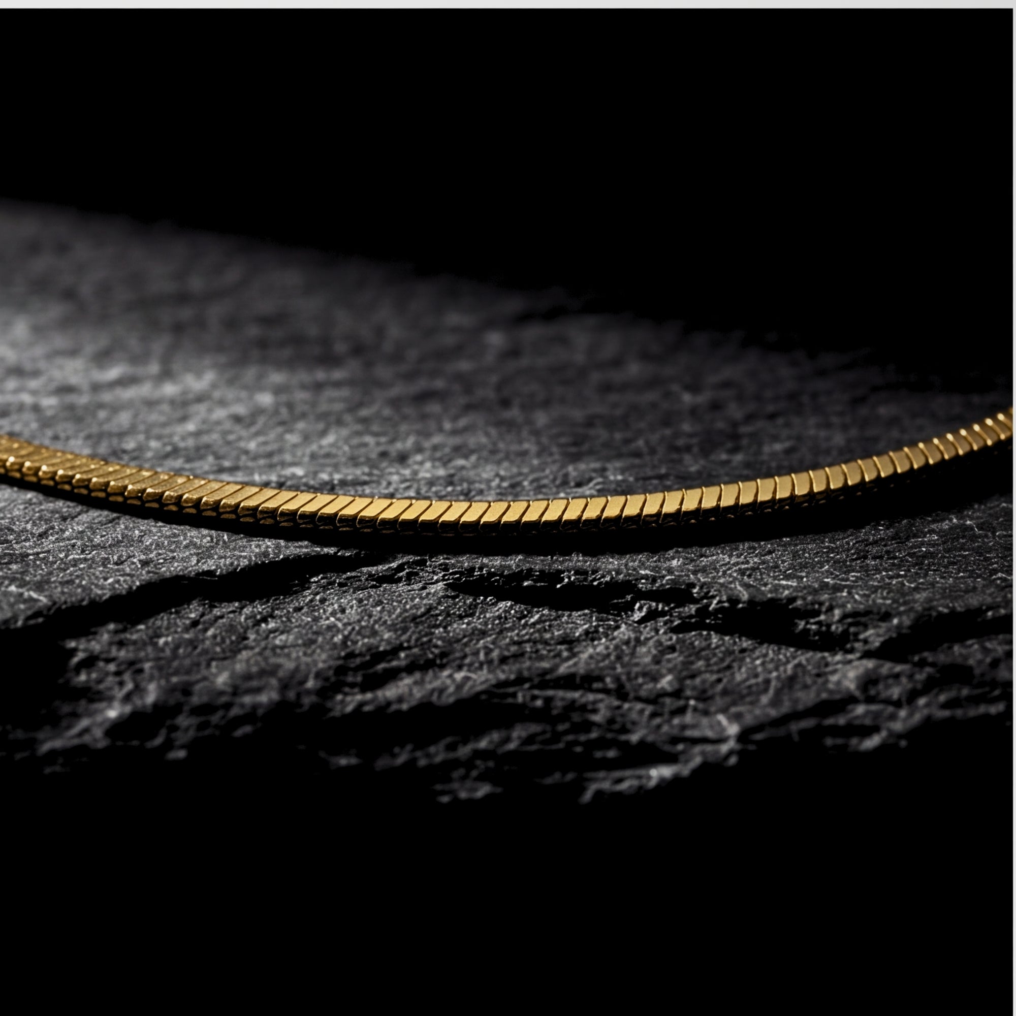 Macro detail of the gold stainless steel square links on the Square Dance Chain.