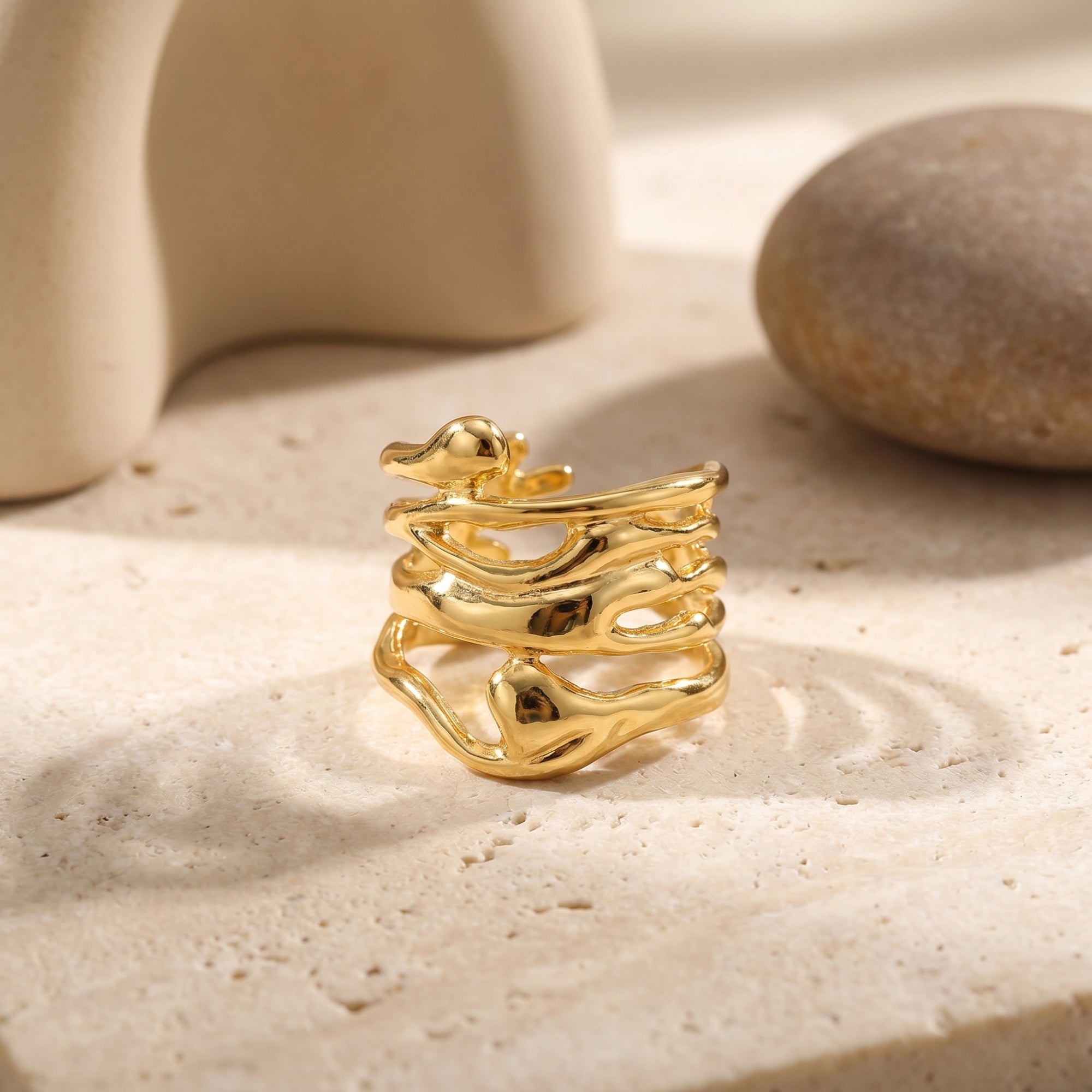 Close-up view of The Marinella Ring, a solid gold ring, highlighting its organic, liquid-like band structure.
