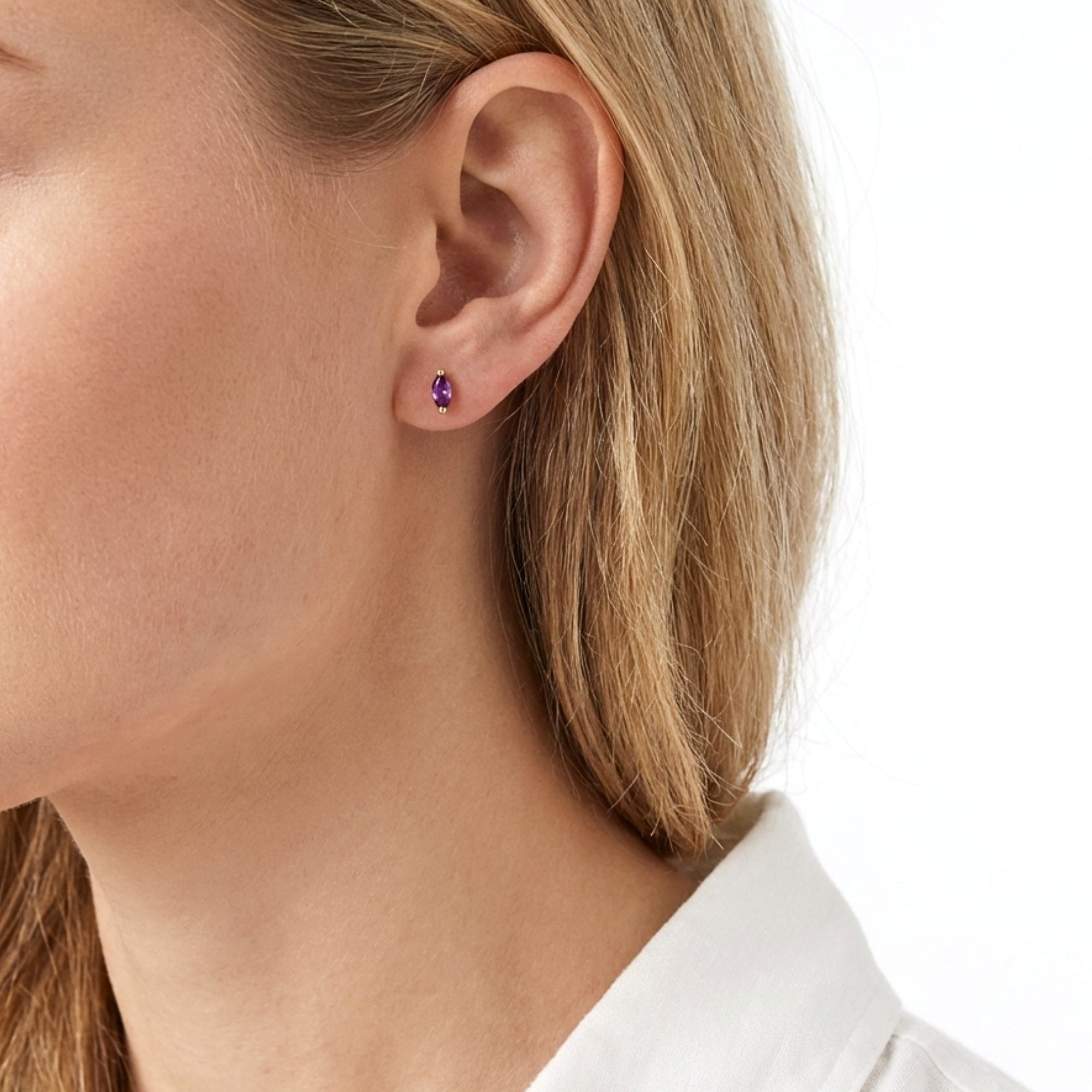 Side profile of a model wearing The Marcella Studs marquise-cut purple simulated amethyst earring in 18K gold vermeil.
