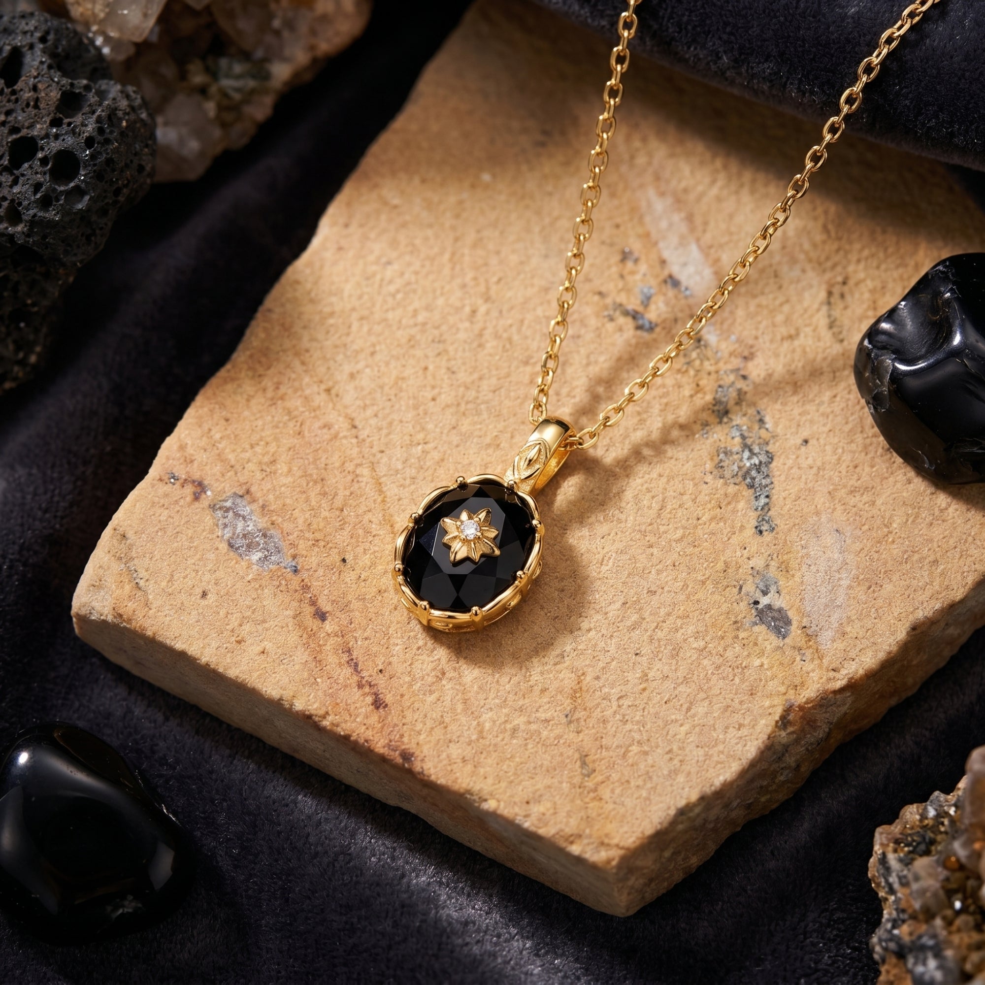 Macro view of the faceted oval-cut black onyx pendant with a gold starburst, resting on a natural stone.