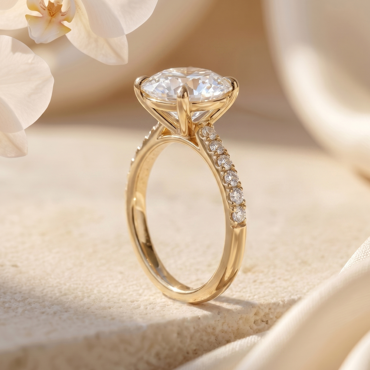 A profile view of a round-cut moissanite engagement ring showing the yellow gold setting and pavé details.
