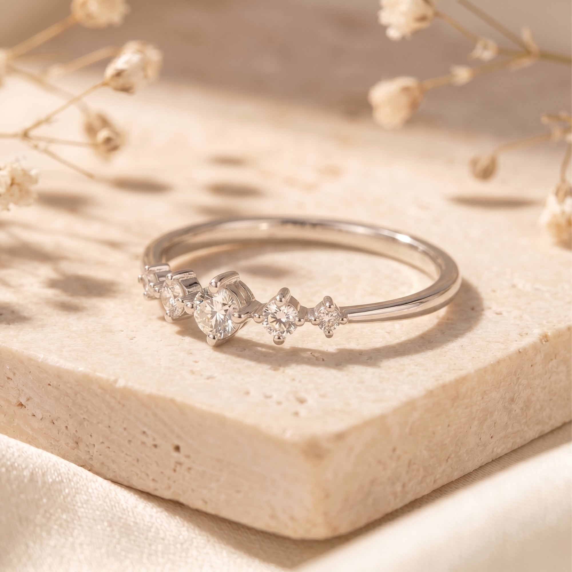 Angled view of silver Elysand ring with graduated round moissanite.