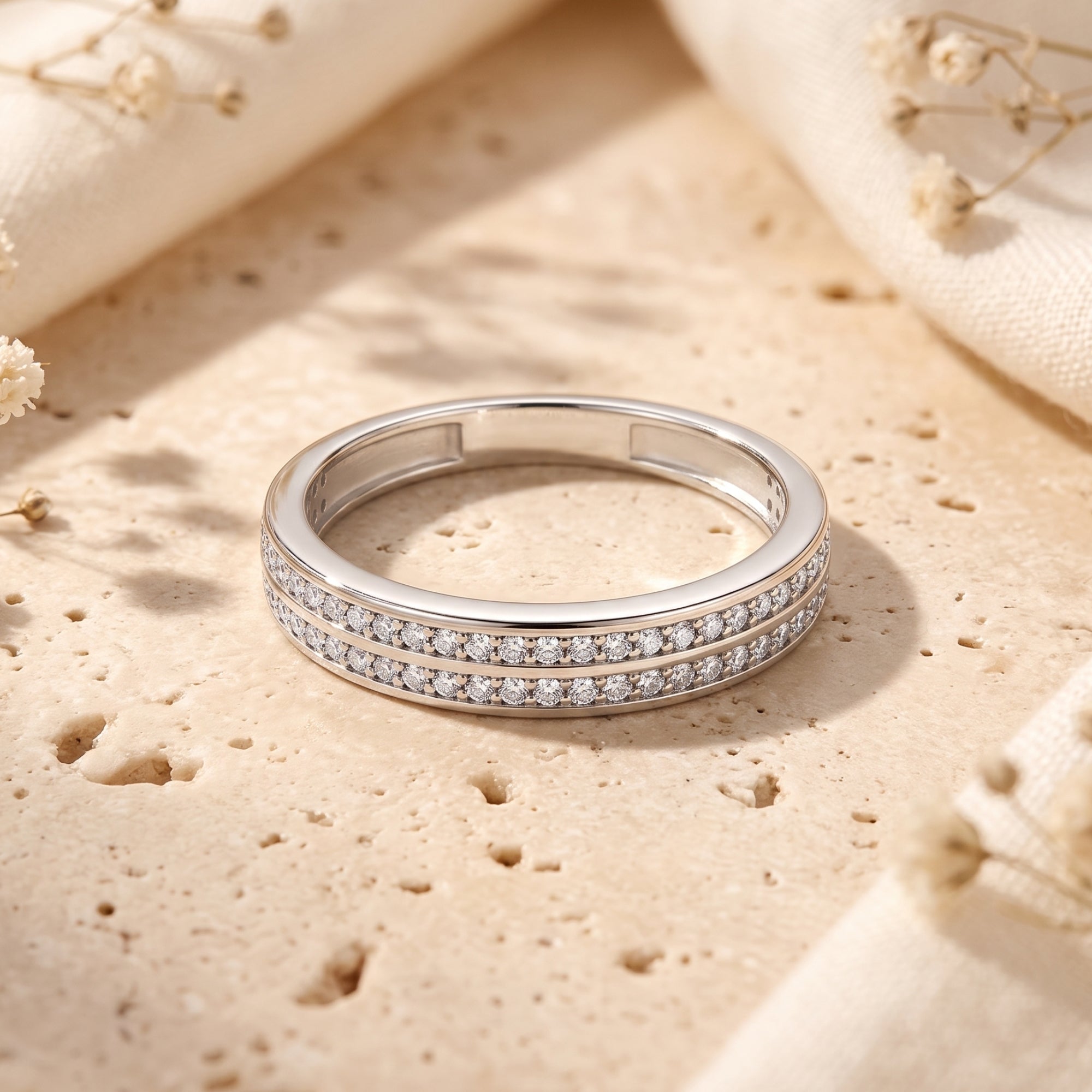 Top-down view of the Margaux double-row pavé sterling silver ring with simulated diamonds on a stone background.