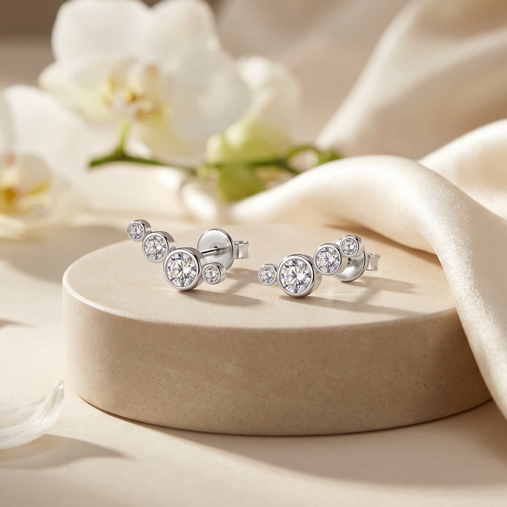 Silver climber earrings featuring round moissanite stones on a stone pedestal with floral accents.