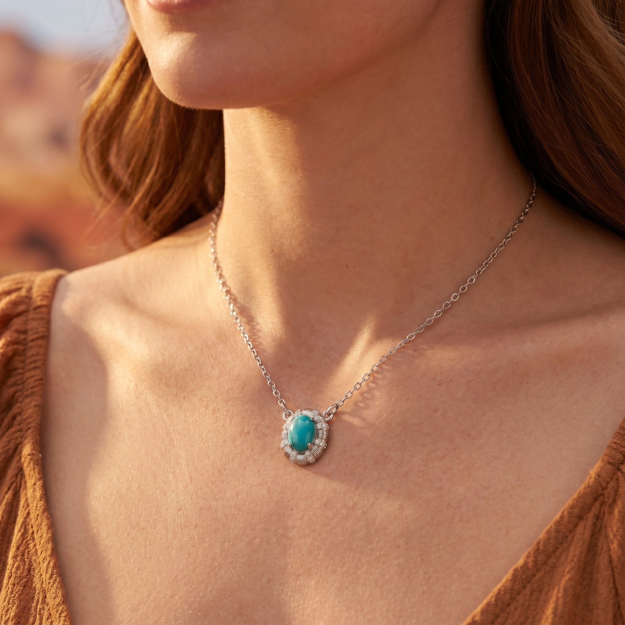 Woman wearing the silver Arizona turquoise necklace with an oval cabochon pendant against a desert landscape.